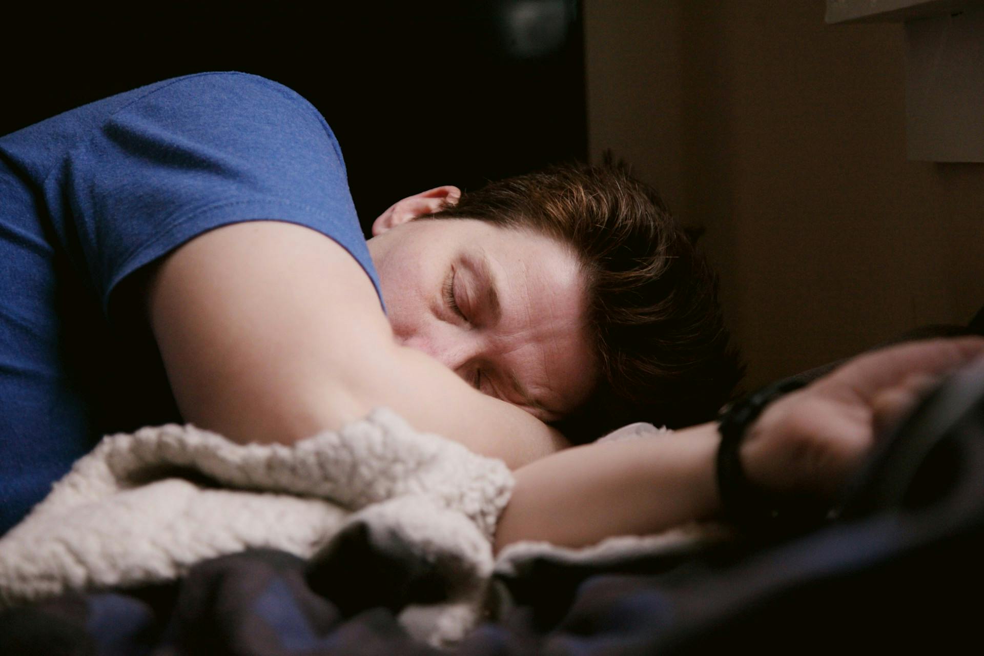 Man sleeping in bed with eyes closed.