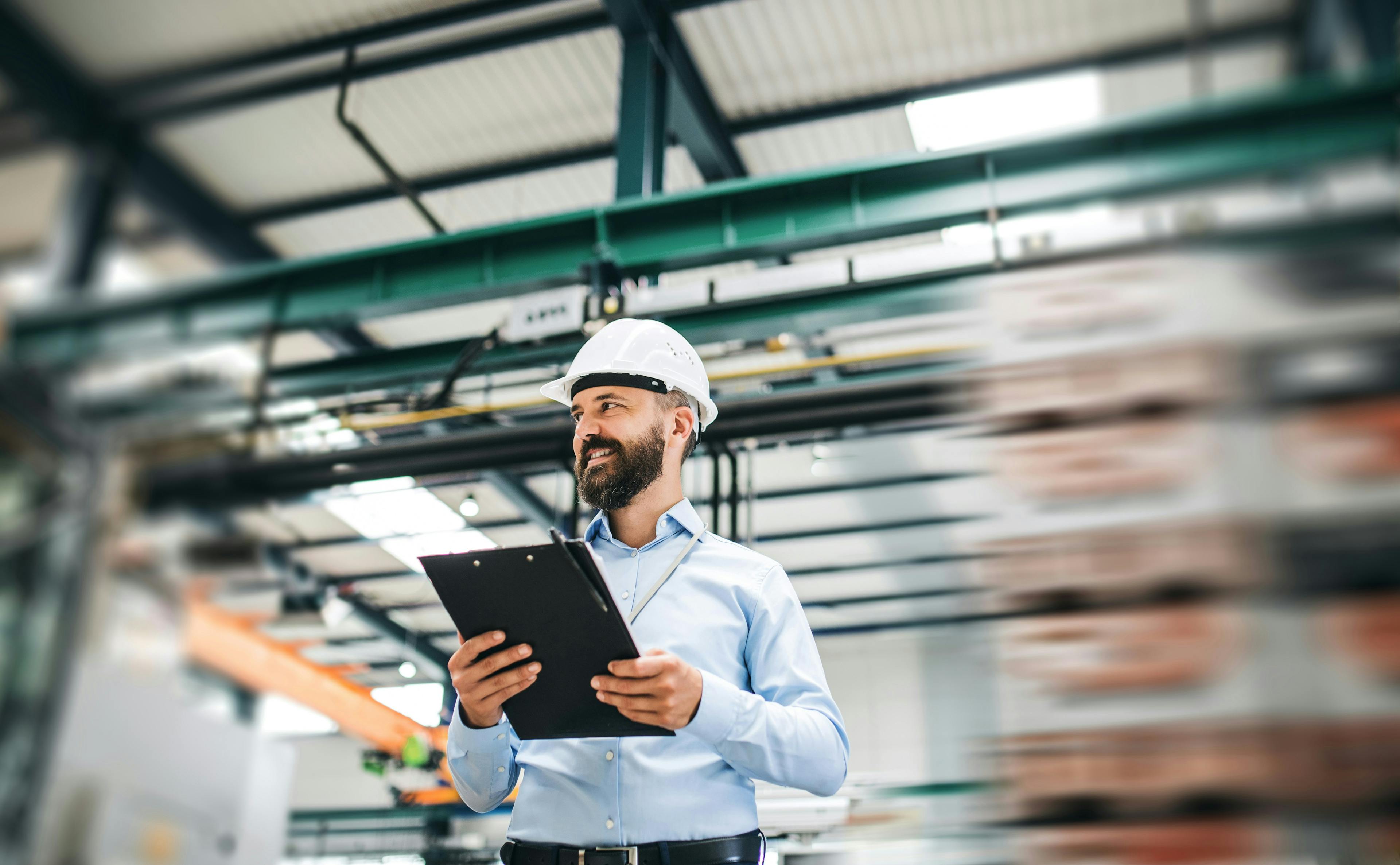 Safety manager with clipboard on warehouse floor