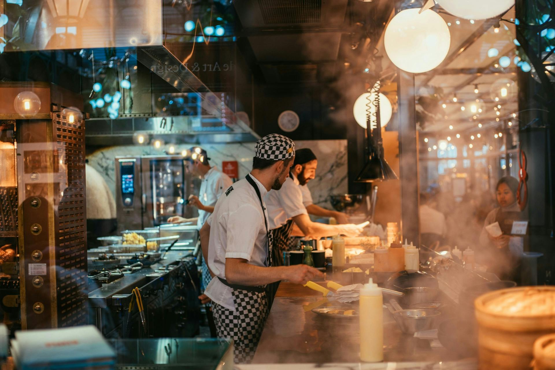 three chefs in a busy restaurant kitchen