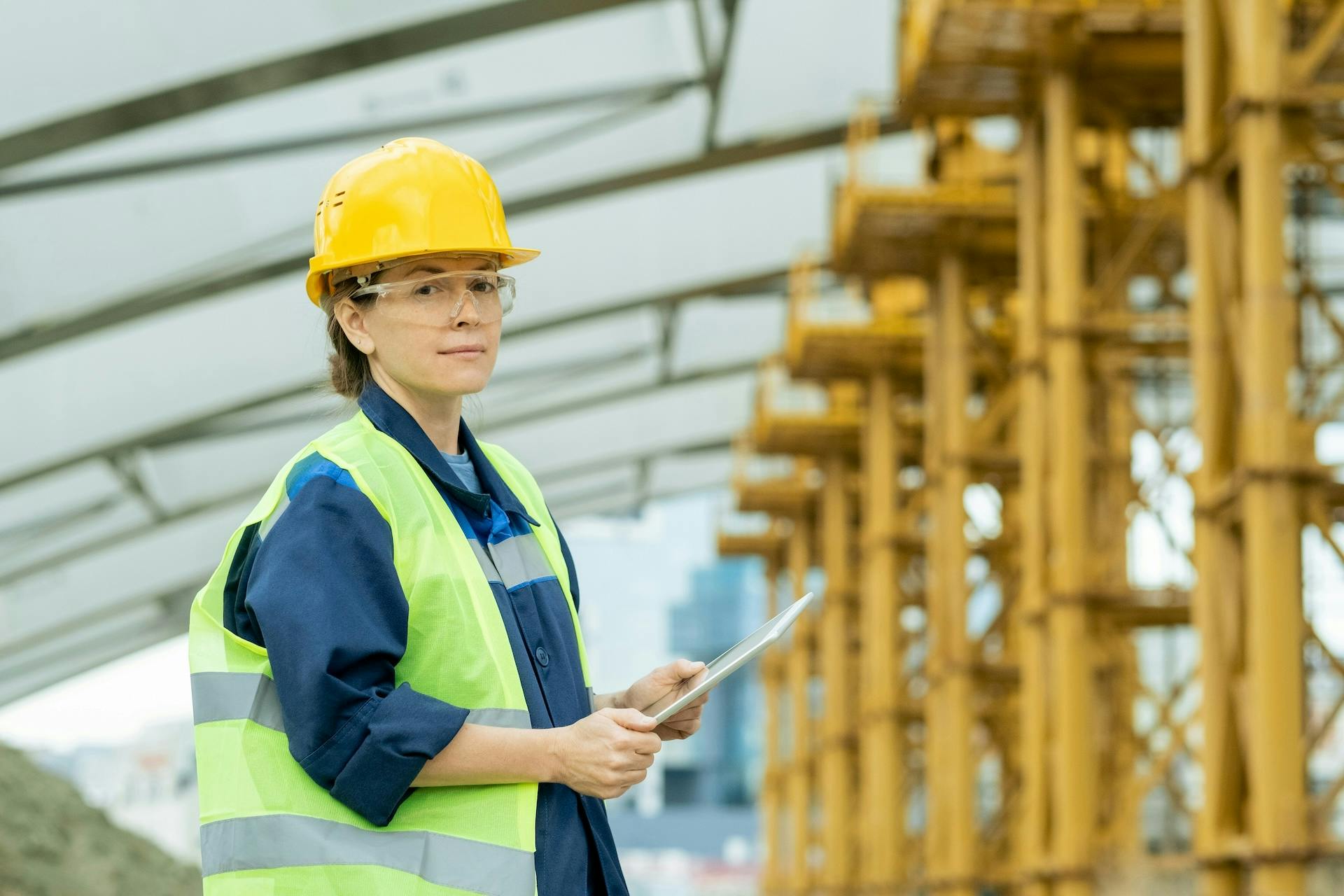 Construction worker using a tablet in an industrial facility.