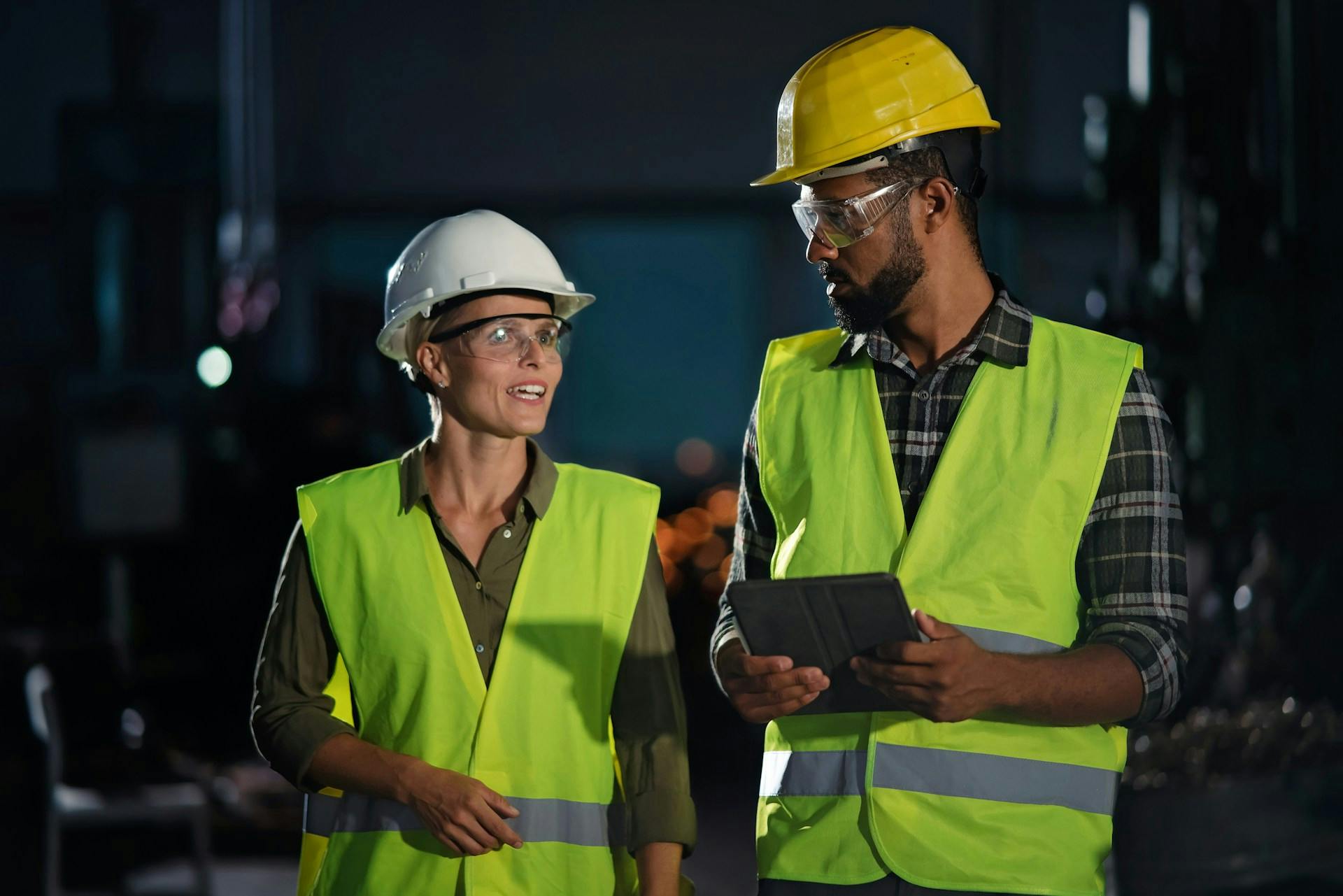 Two workers in hi-vis vests and hard hats.