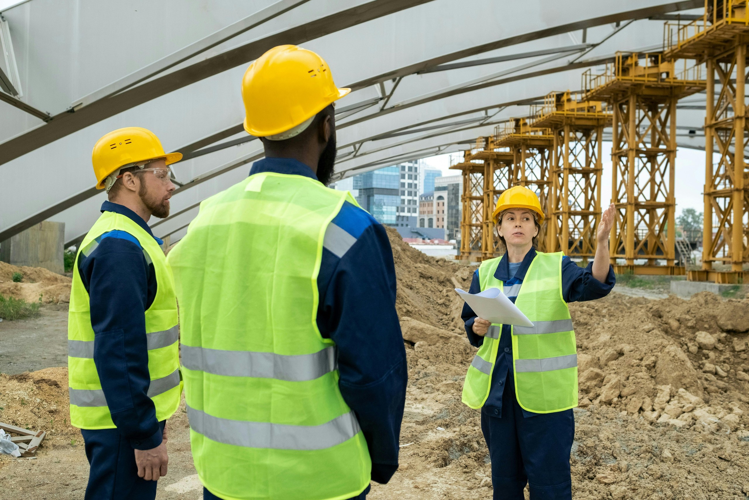 Three construction workers talking on job site