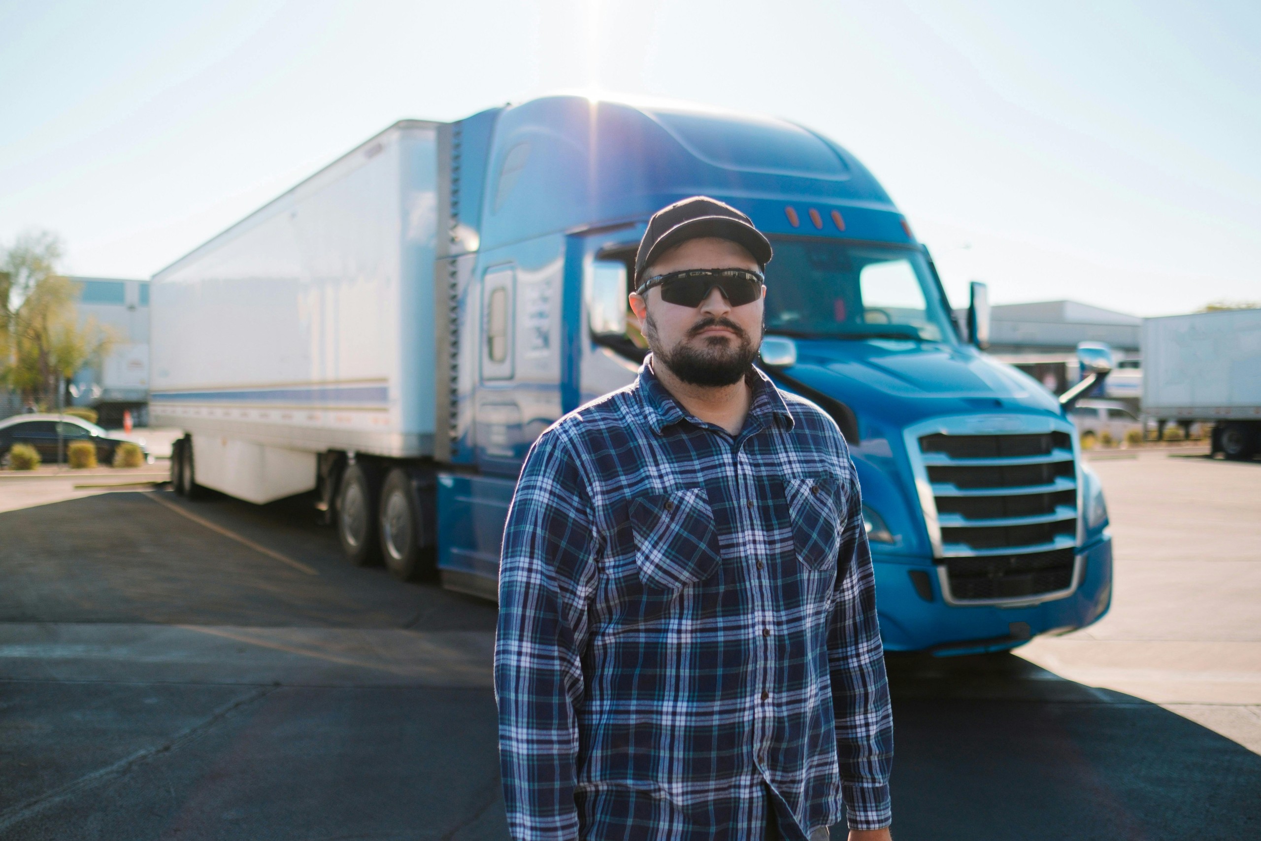 Truck driver standing in front of a semi truck