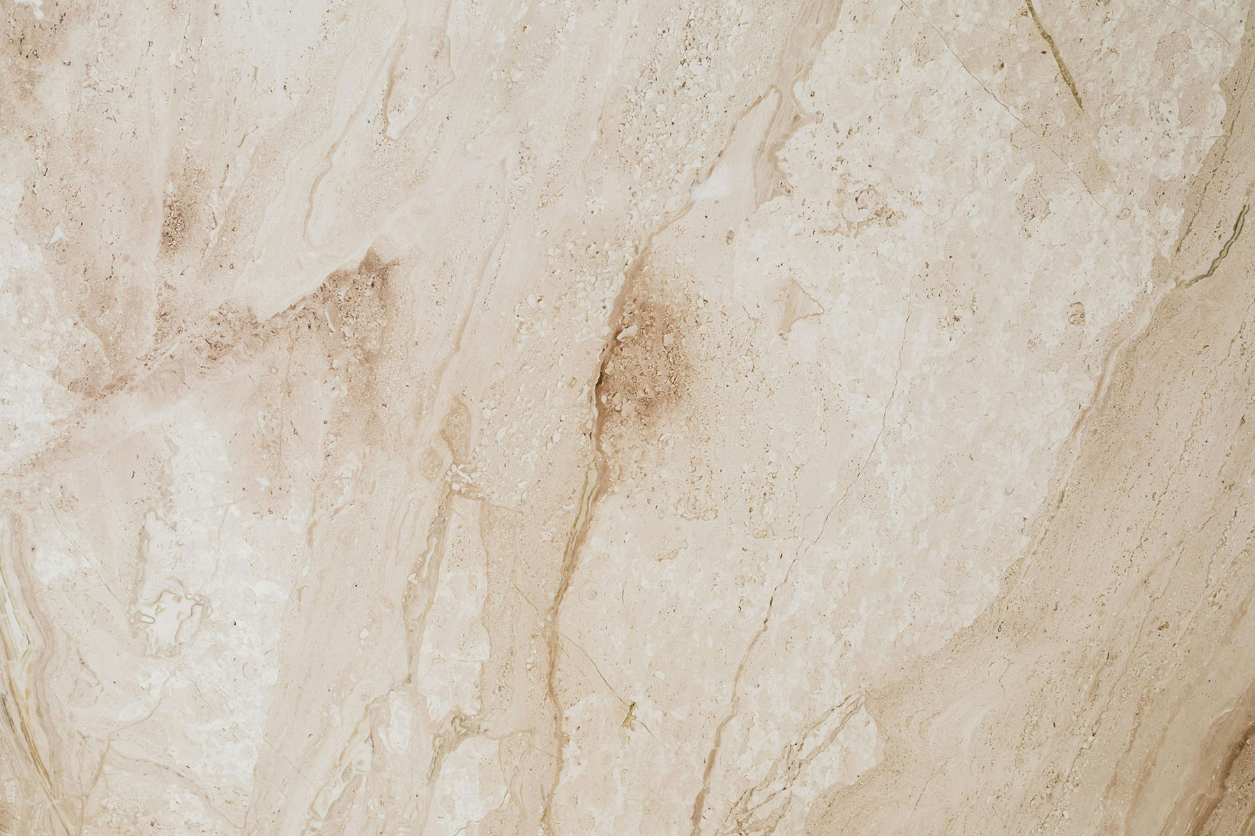 Beige marble surface with natural veins and textured patterns in light brown and cream tones.