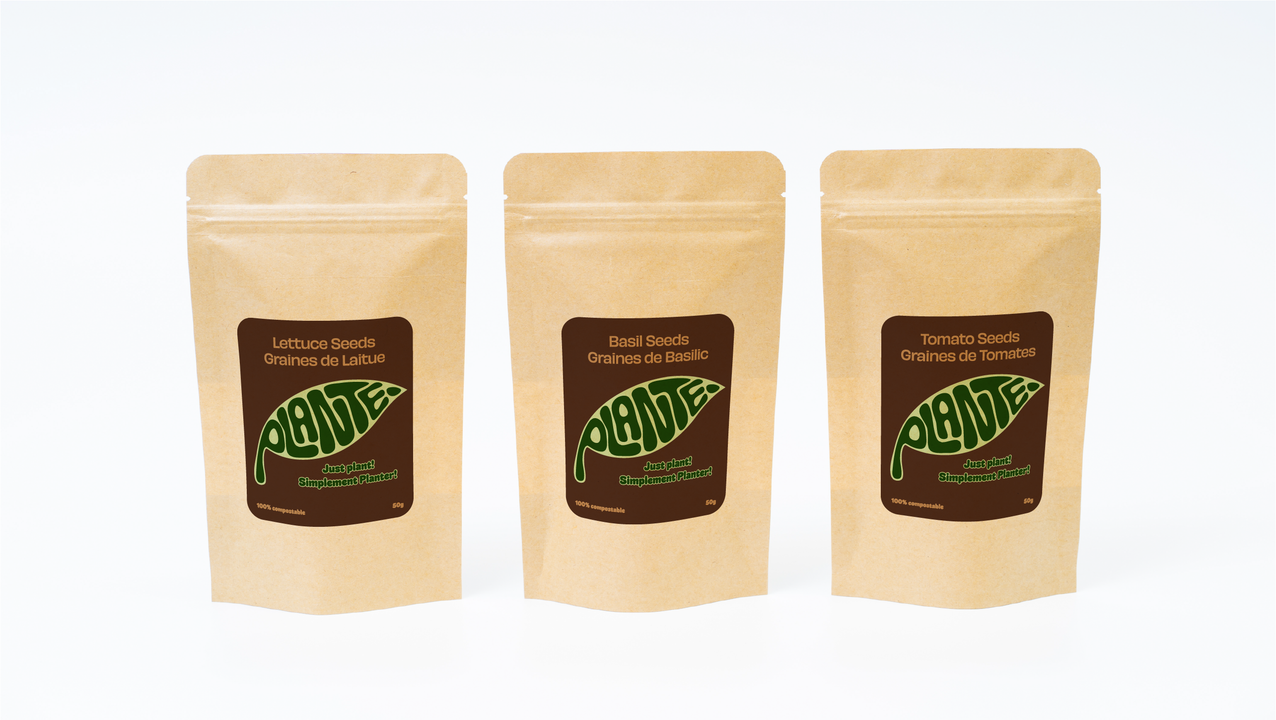 Three brown compostable seed packets labeled lettuce, basil, and tomato seeds with green leaf logo.