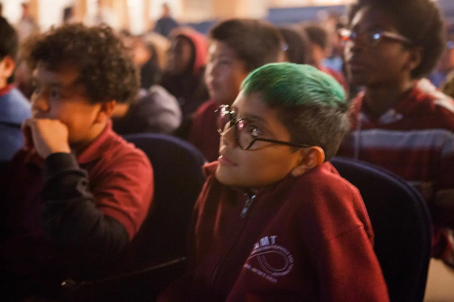 Students seated in an auditorium attentively watching a presentation