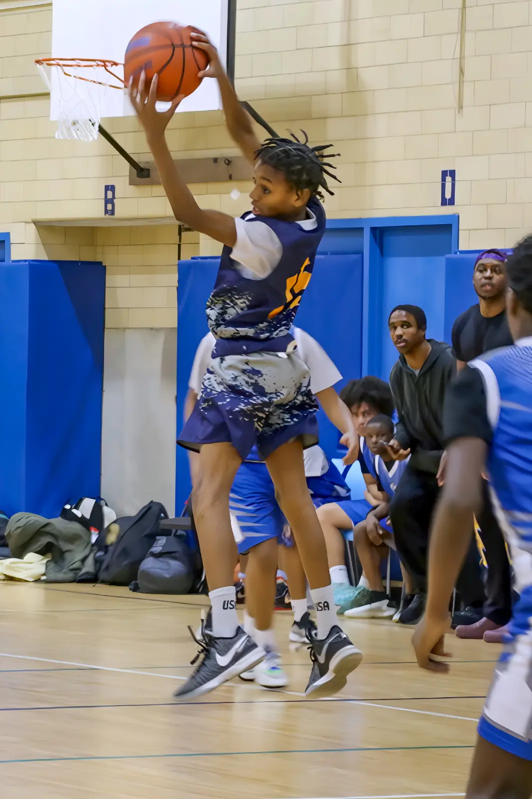 Student athlete jumping to make a basketball shot during game