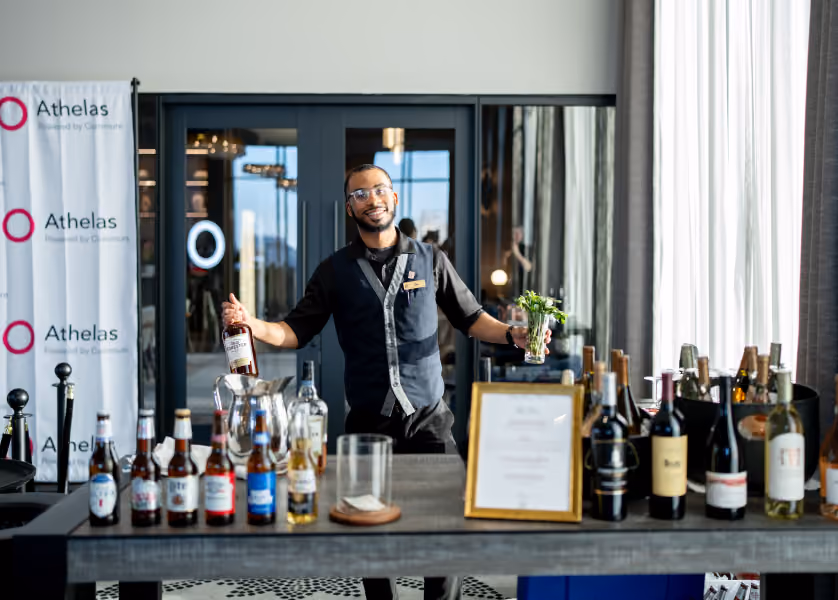 Bartender serving drinks at an event bar.