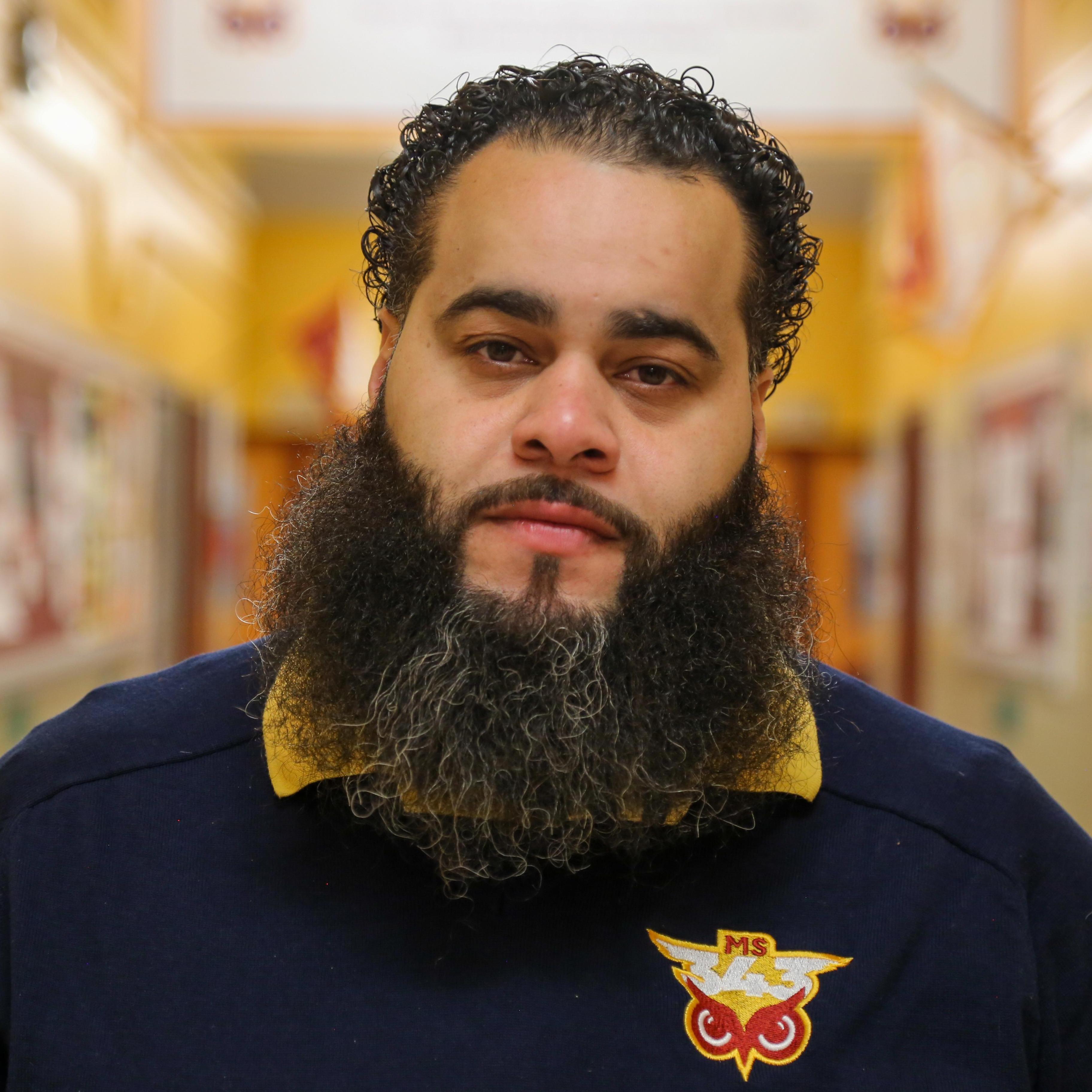 Mr. Quiles staff portrait in school hallway