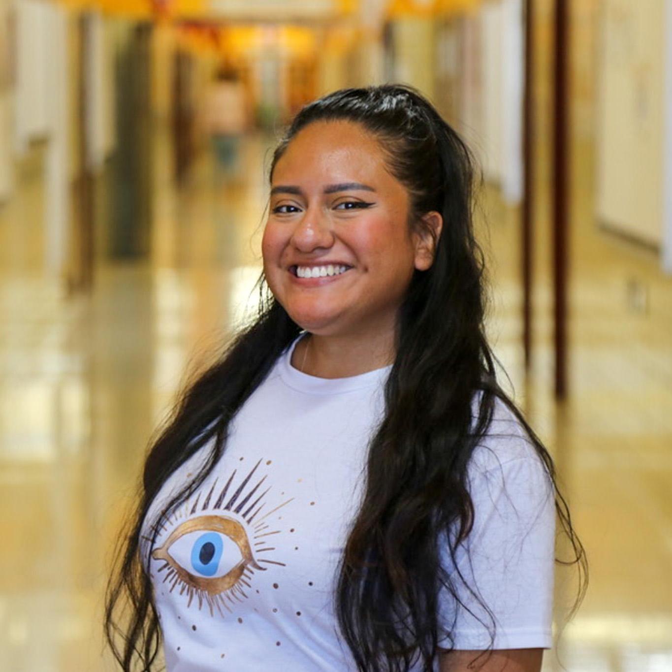 Ms. Leon-Valdez smiling in a school hallway