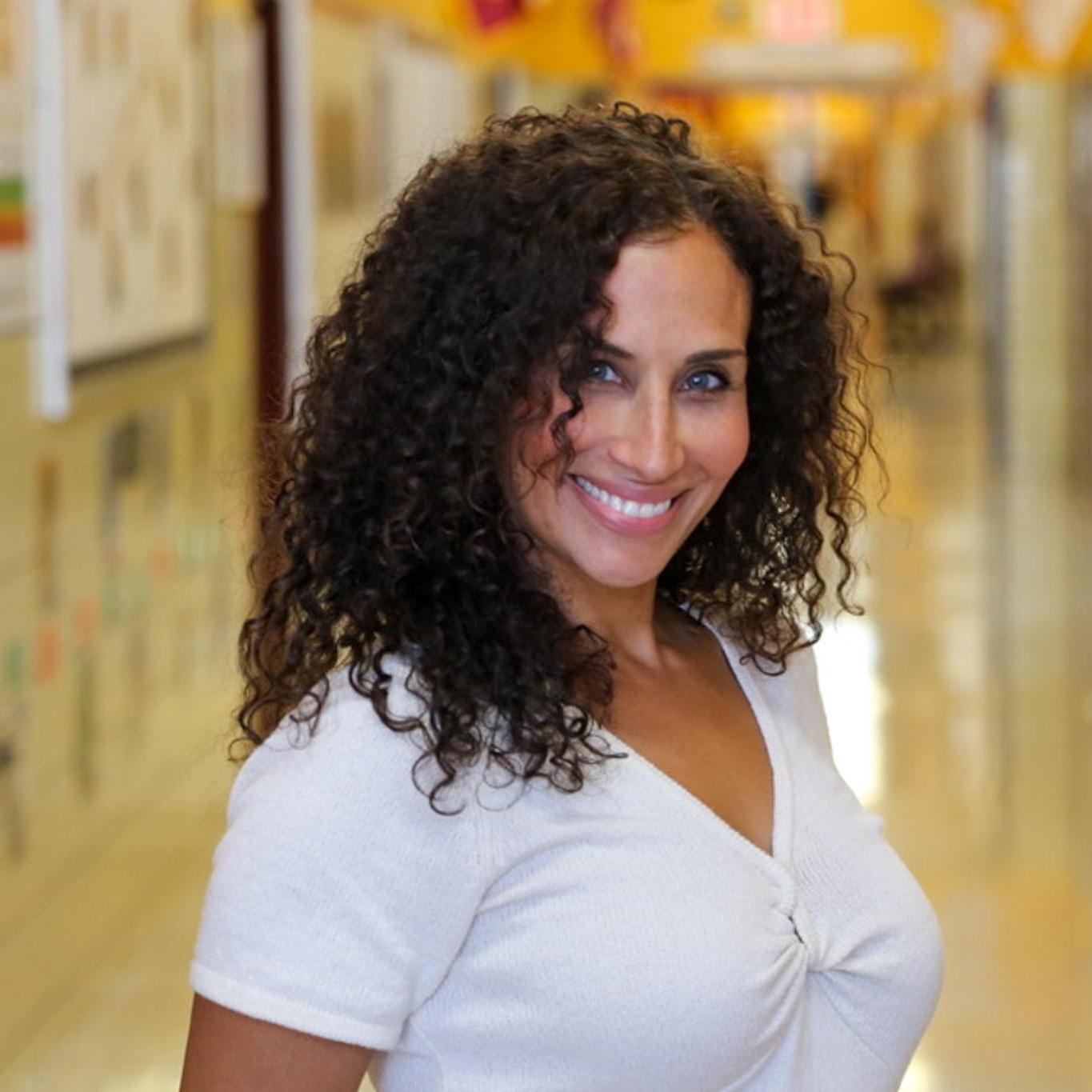 Ms. Acevedo smiling in a school hallway