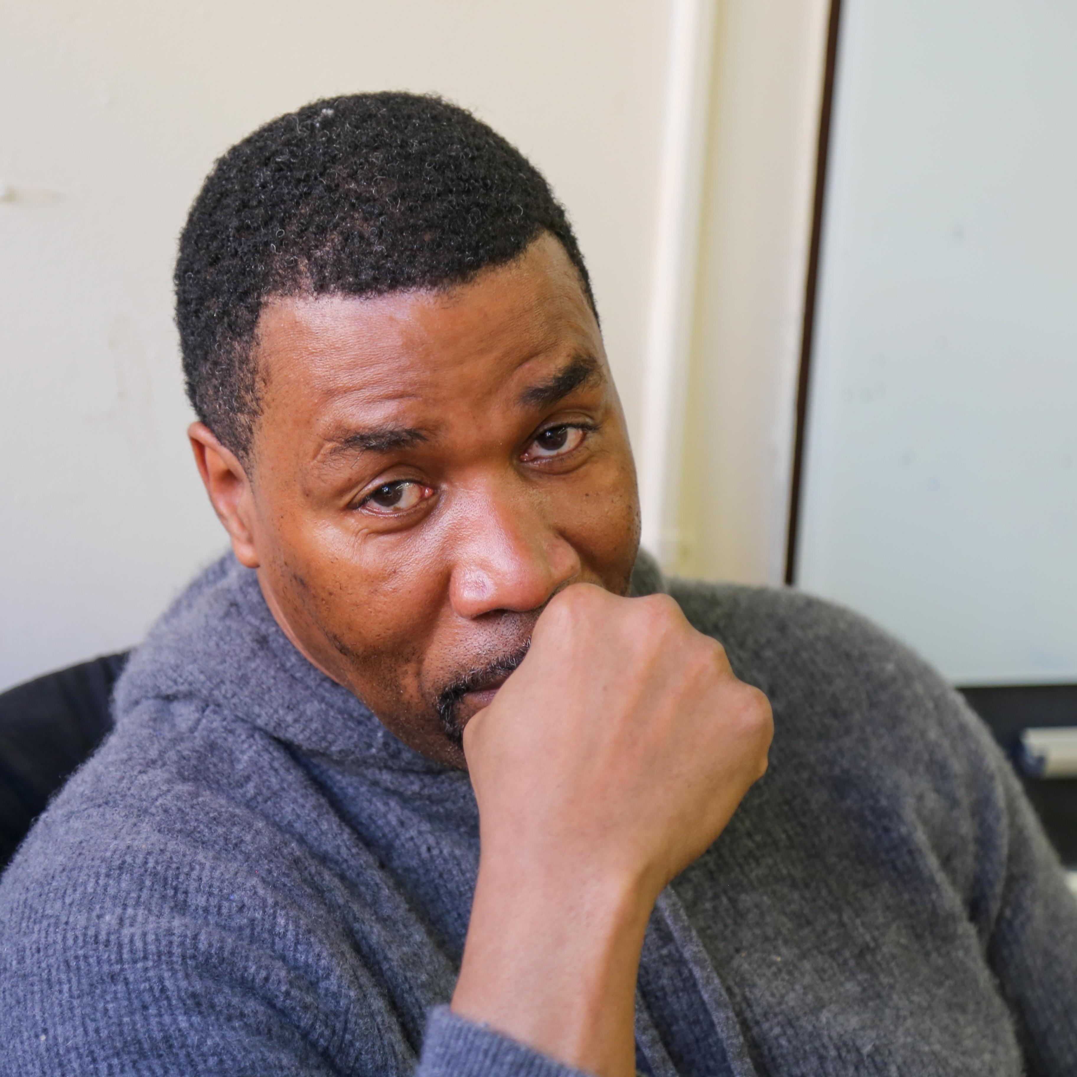 Mr. Beckford staff member seated in thoughtful pose