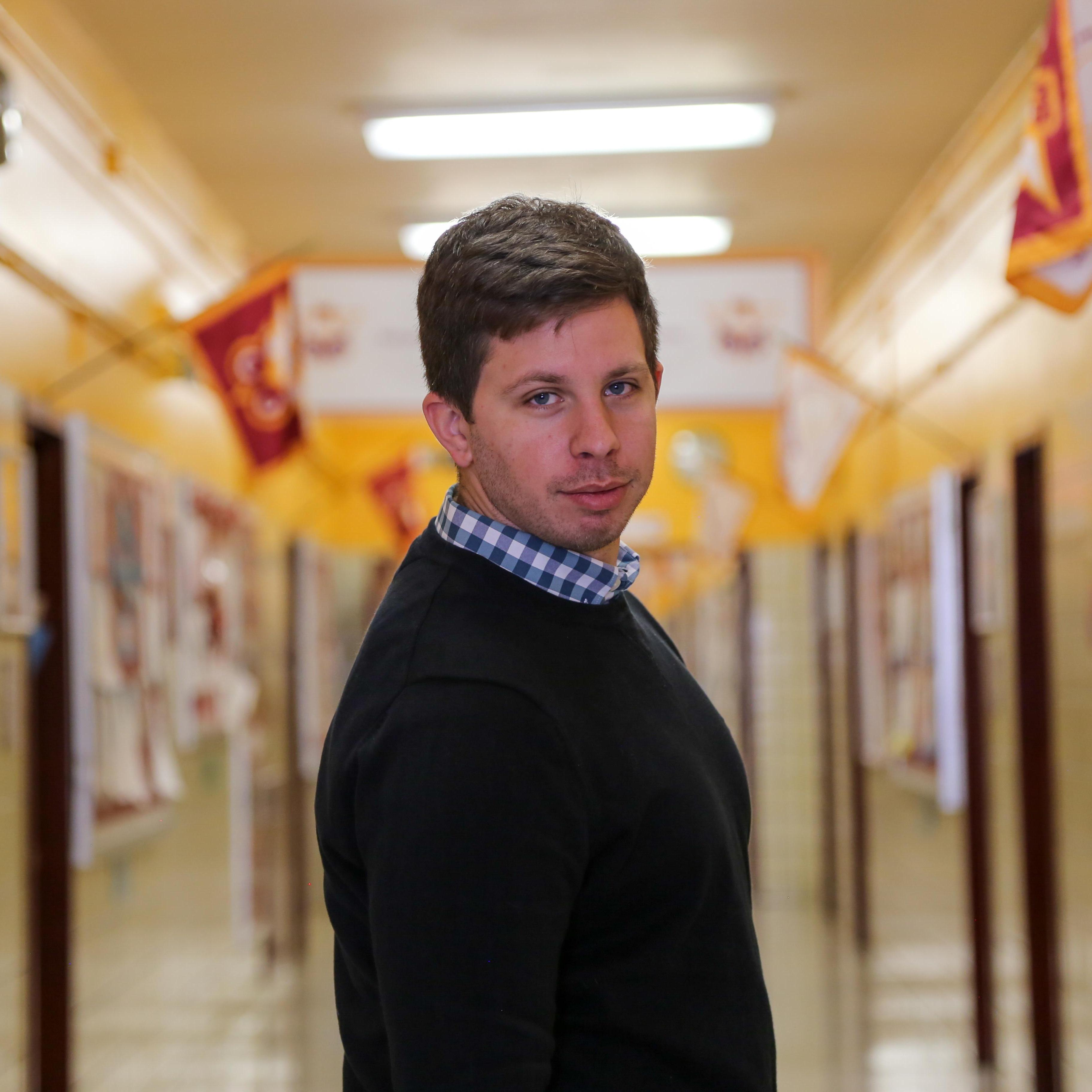 Mr Beja standing in a decorated school hallway
