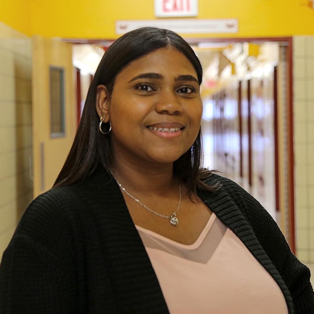 Mrs. Delgado smiling in a school hallway