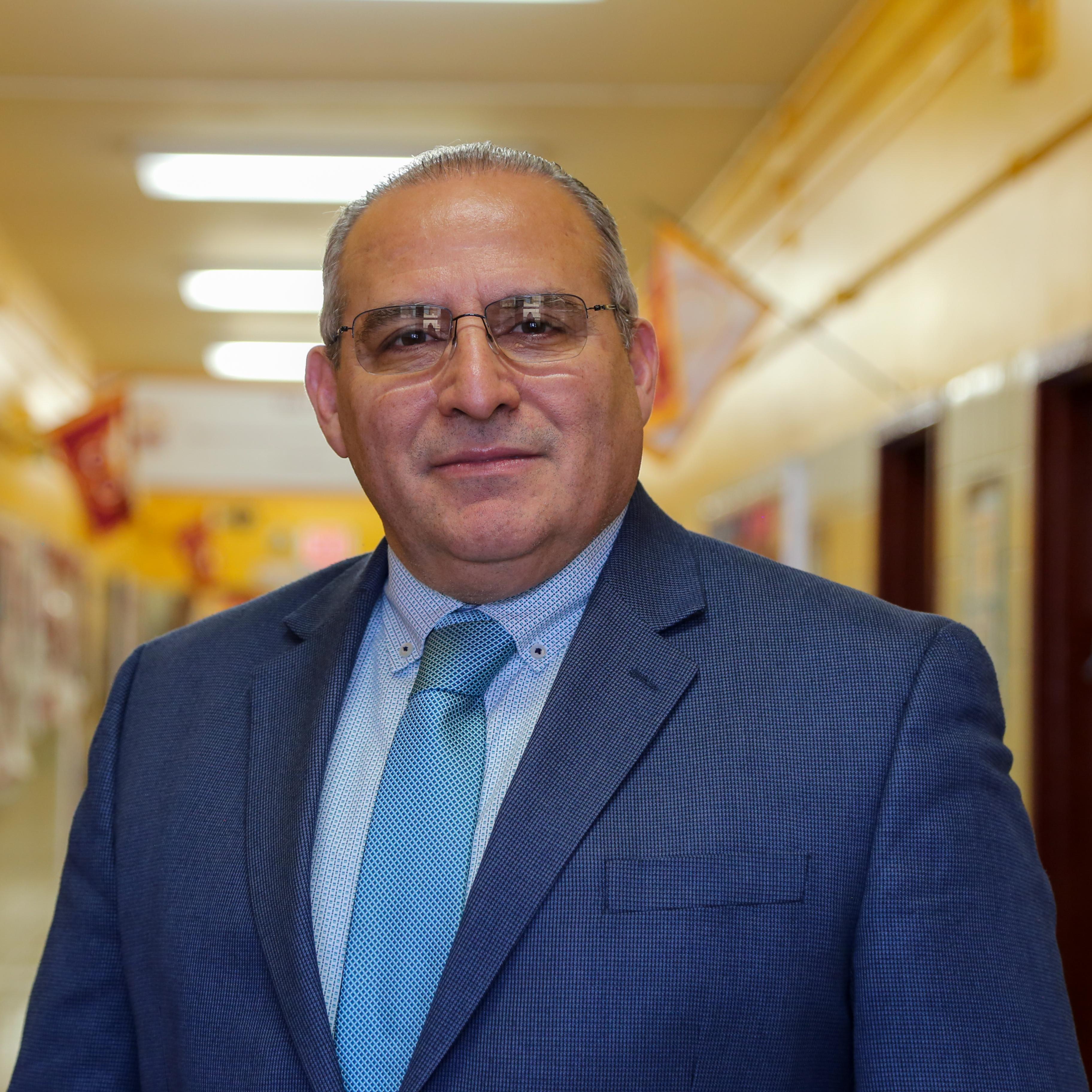 Mr. Lopez staff member posing in school hallway