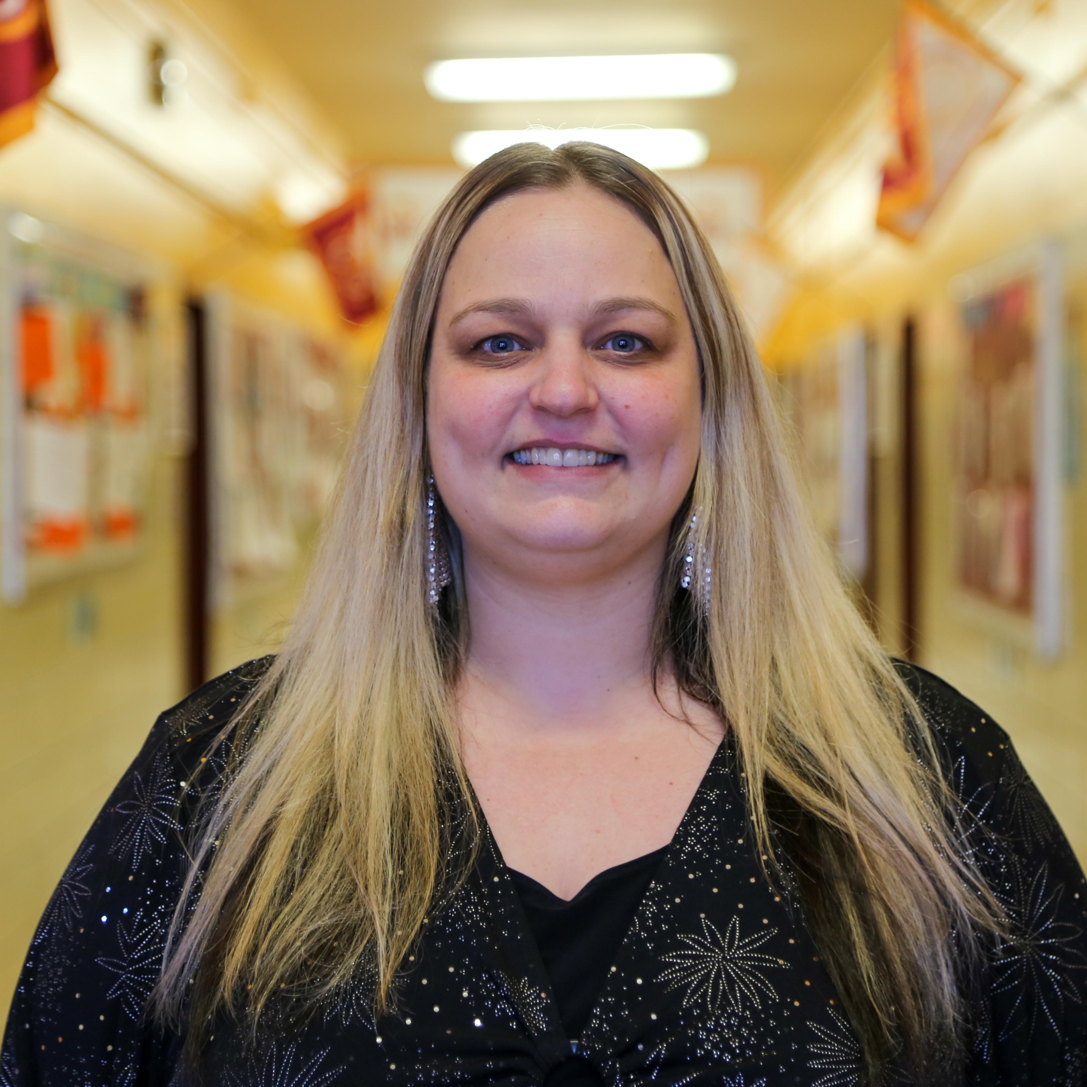 Ms. Lott smiling in a school hallway