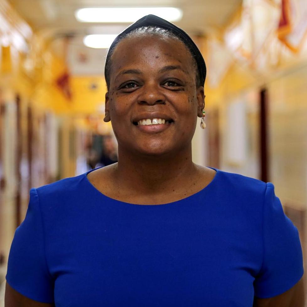Ms. Palmer-Williams smiling in a school hallway