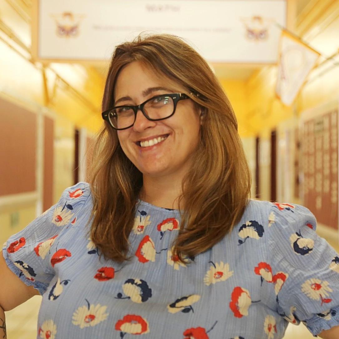 Ms. Prusecki smiling in a school hallway