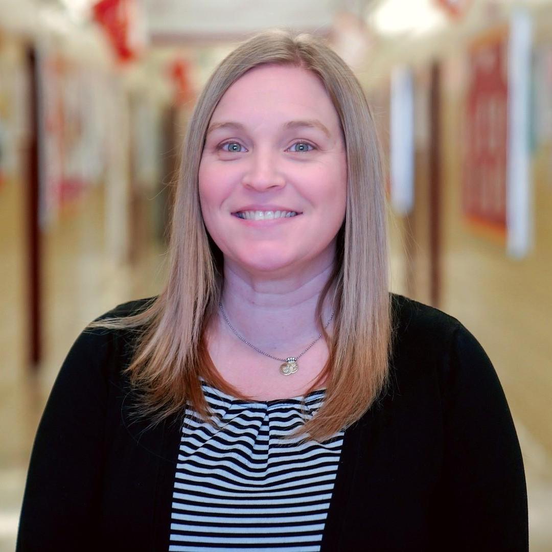 Ms Shapiro smiling in a school hallway