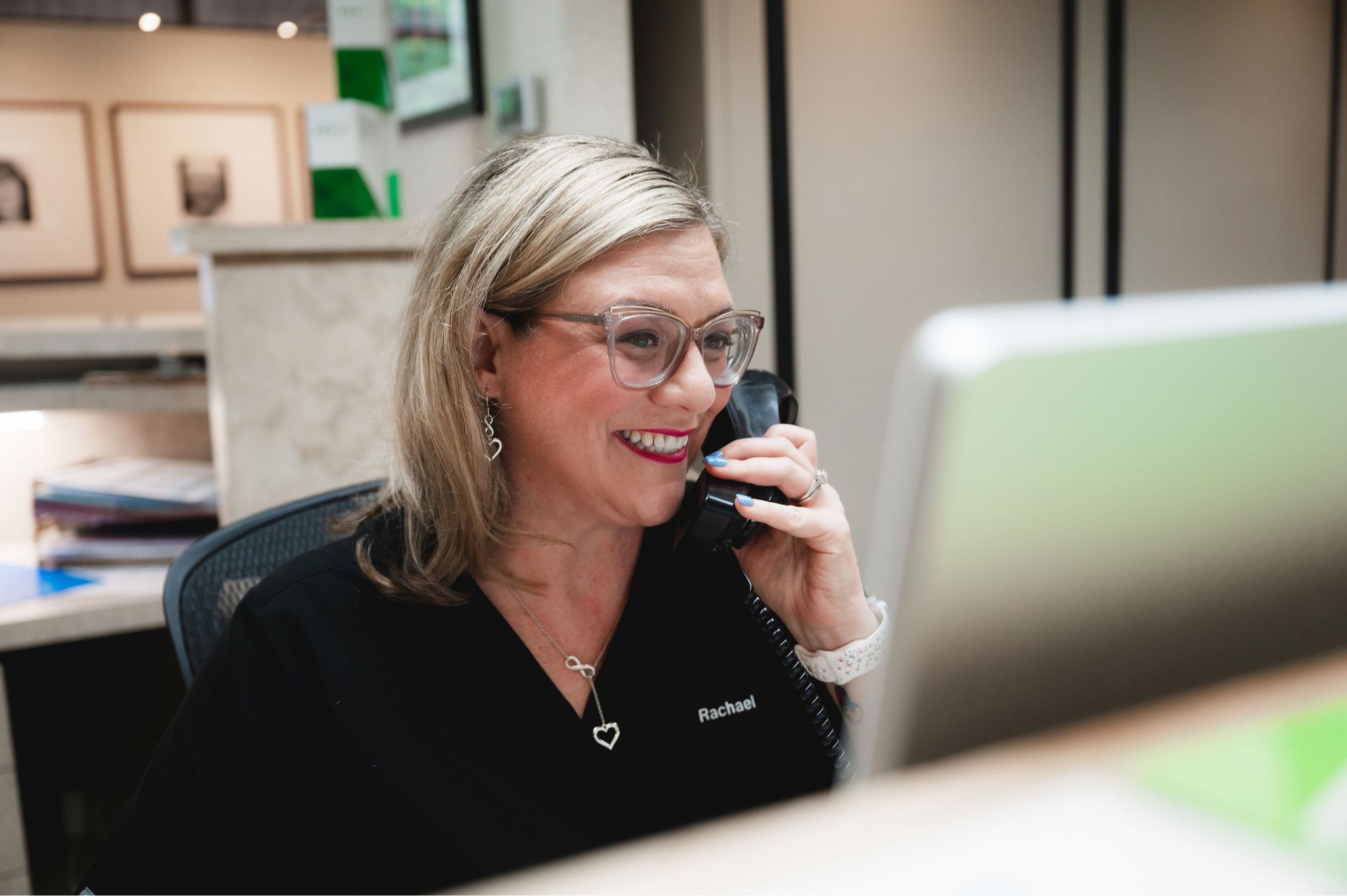 Rachael, a Greene & Ratcliff team member, answering the phone at her desk.