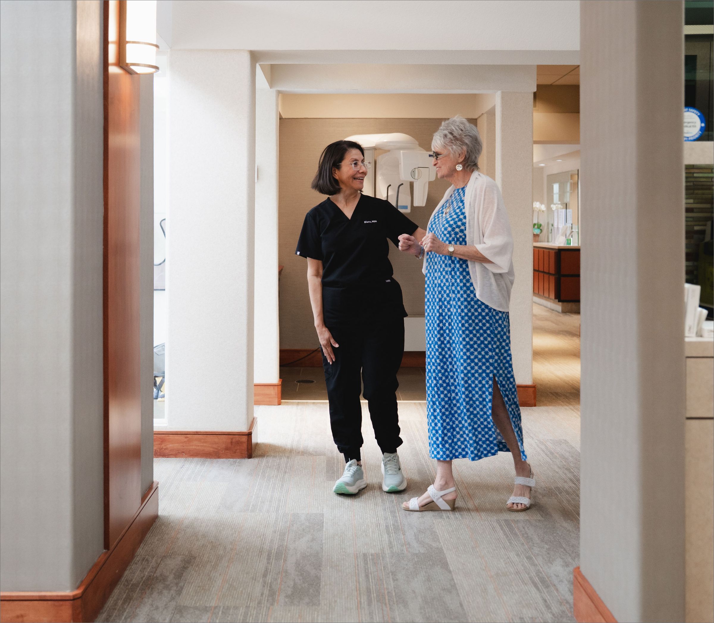 Team member walking down the hallway with a patient.