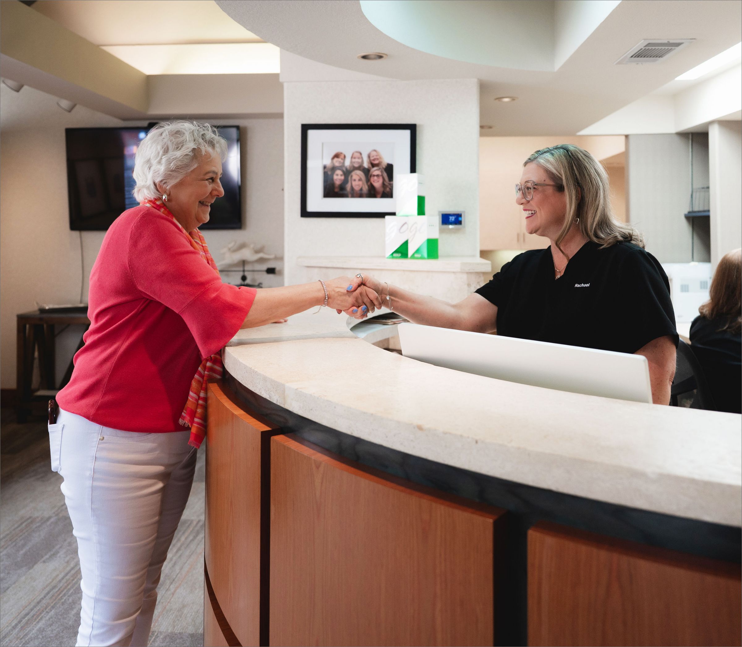 Patient shaking hands with a team member at the Greene & Ratcliff front desk.
