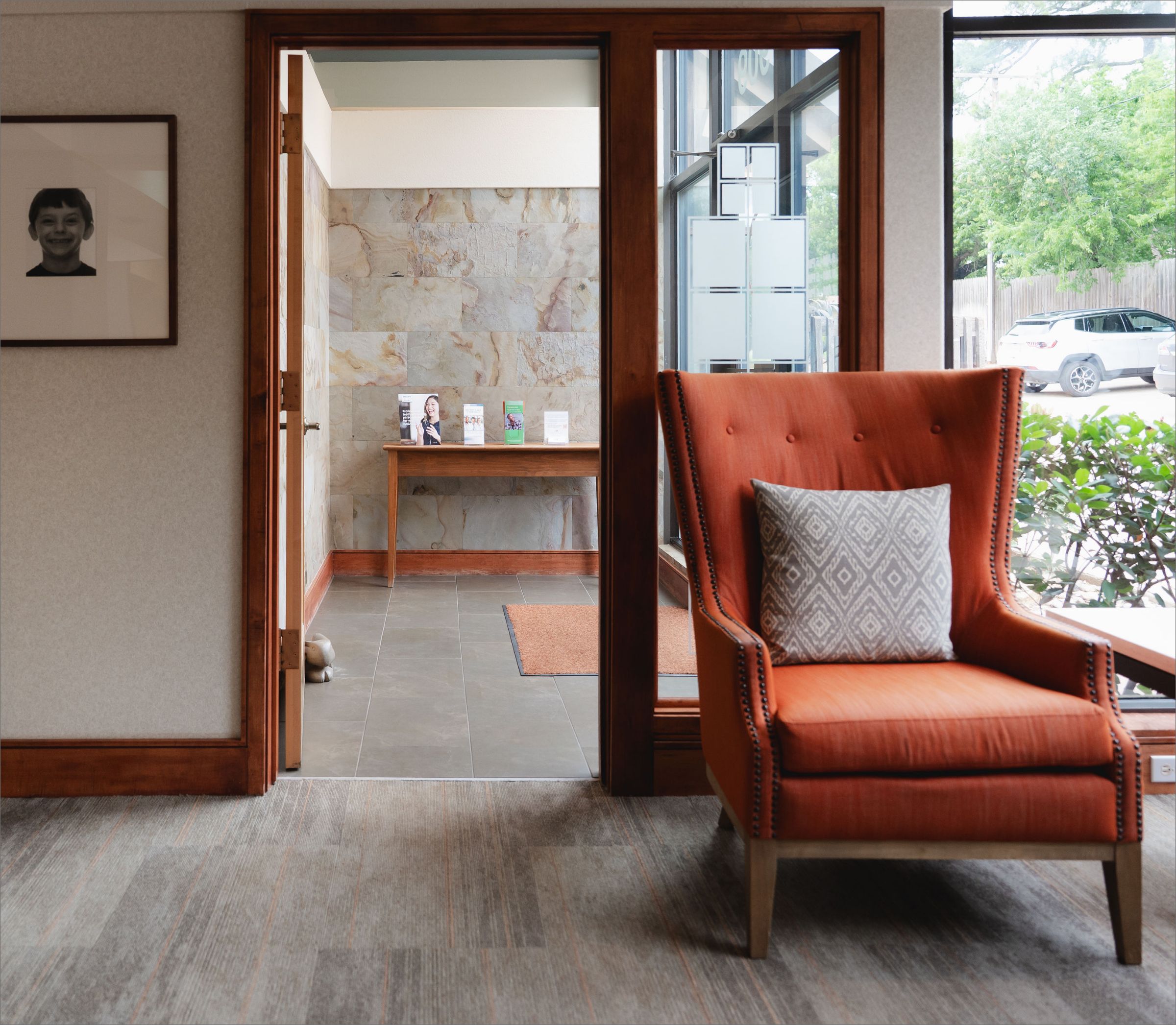 Greene & Ratcliff waiting room with an orange armchair and view into the reception area.