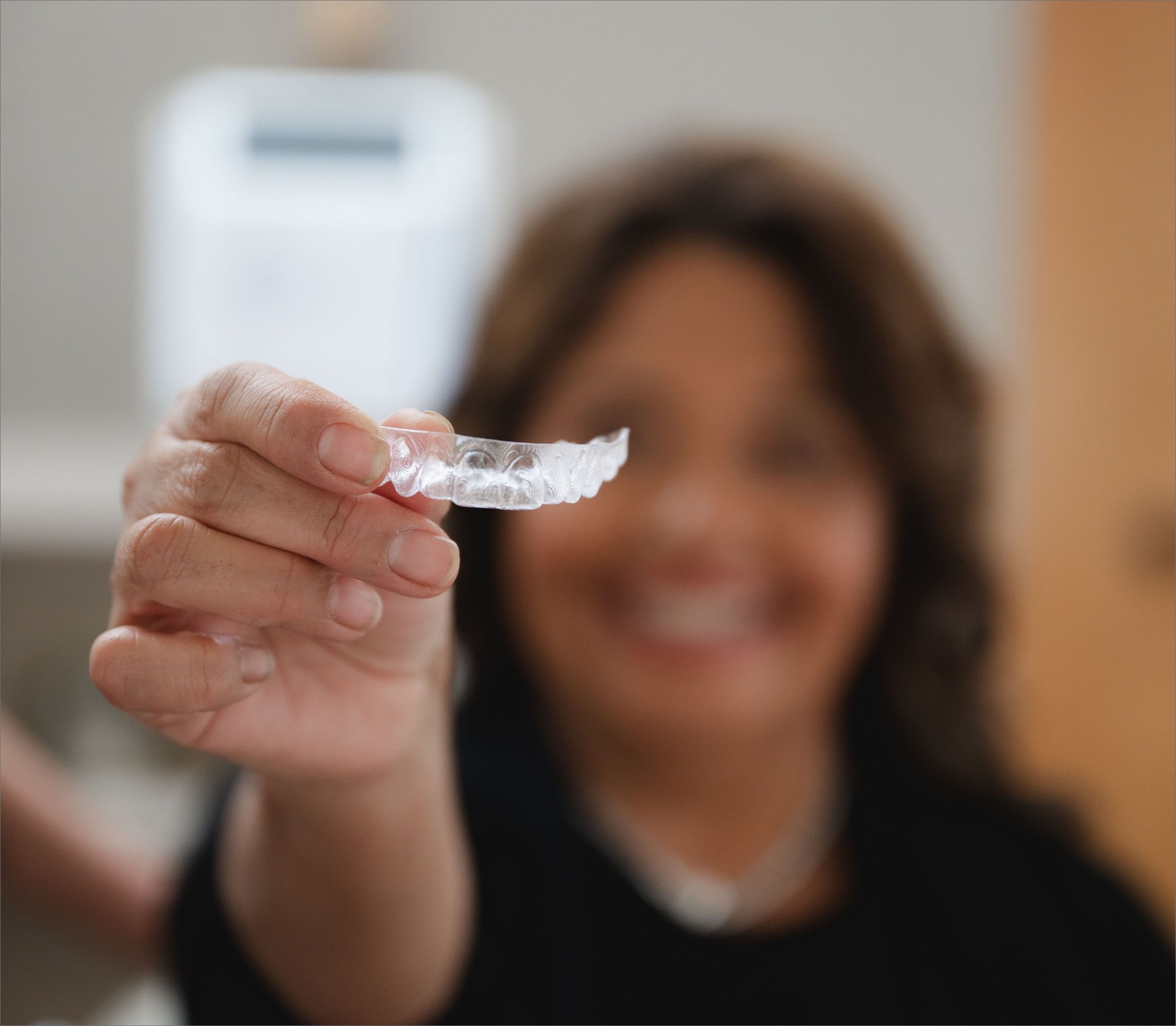 Team member holding a clear dental aligner.