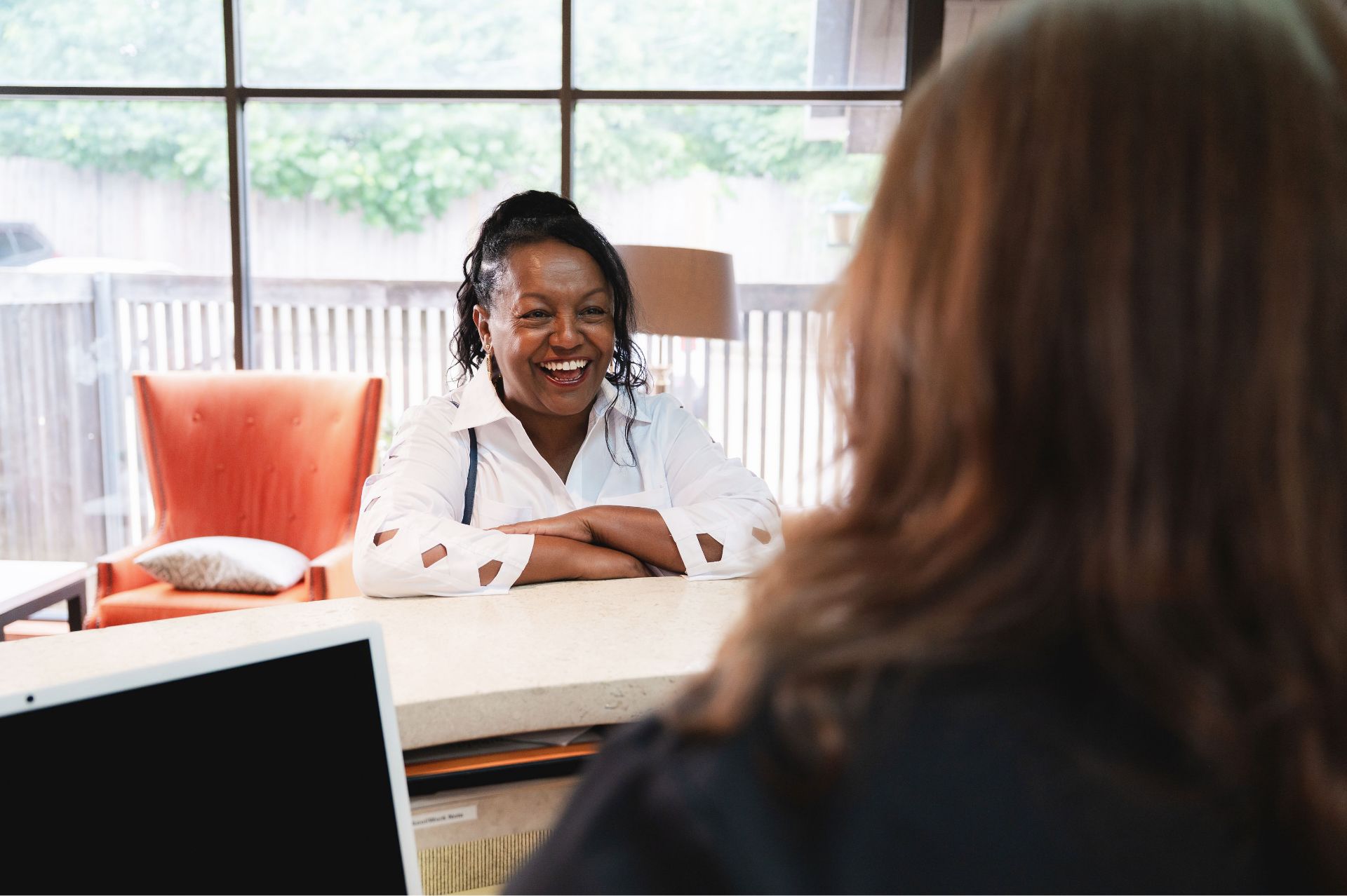 Smiling patient seated at a desk in the Greene & Ratcliff office.
