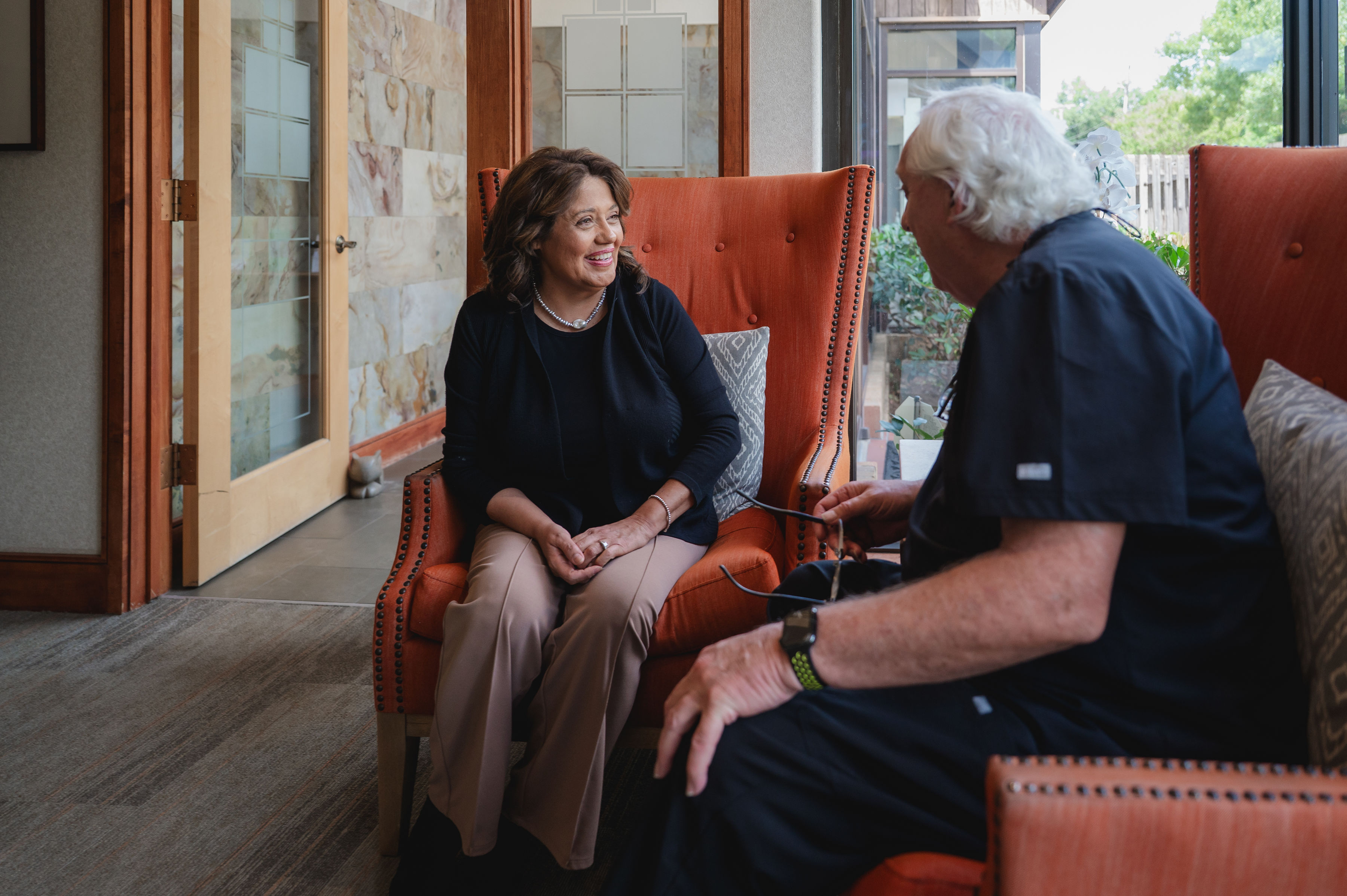Dr. Ratcliff talking with a patient seated in the Greene & Ratcliff reception area.