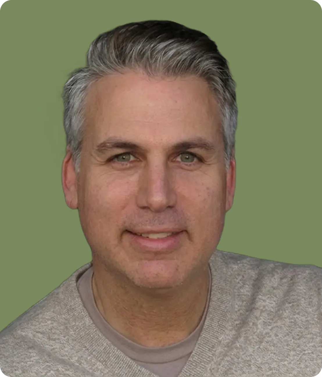 Middle-aged man with gray hair wearing a beige sweater, smiling against a green background.