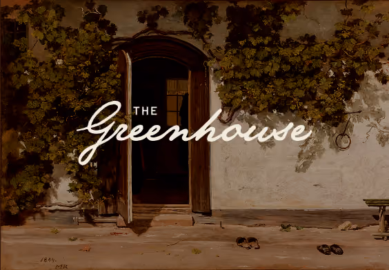 Open wooden door set in a wall with climbing ivy on each side, two pairs of shoes on the ground, with the text 'The Greenhouse' overlaid in cursive font.
