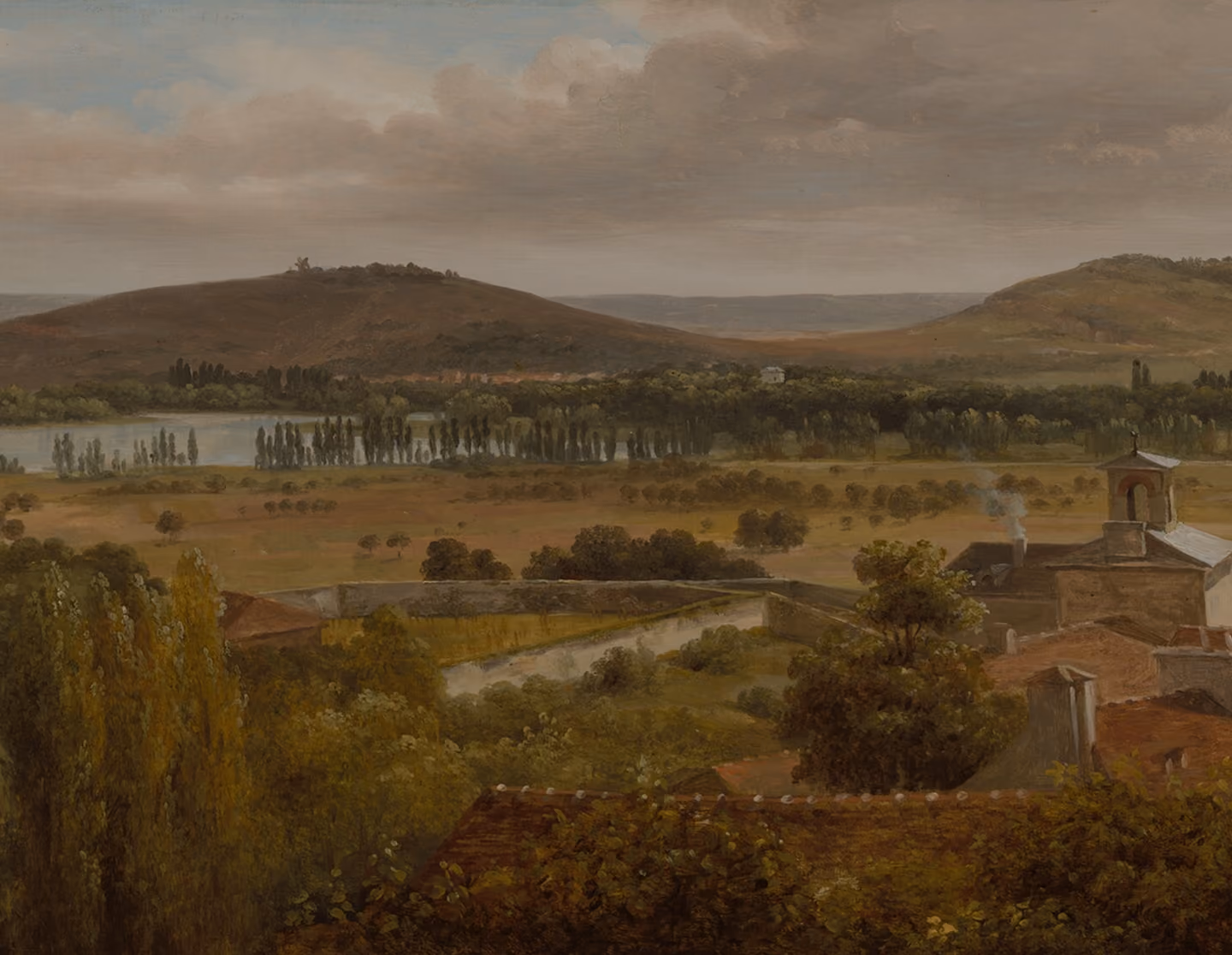 A serene landscape with rolling hills in the background, a wide river bordered by tall trees, and a foreground featuring lush greenery and buildings with red-tiled roofs, including a small church tower emitting smoke.