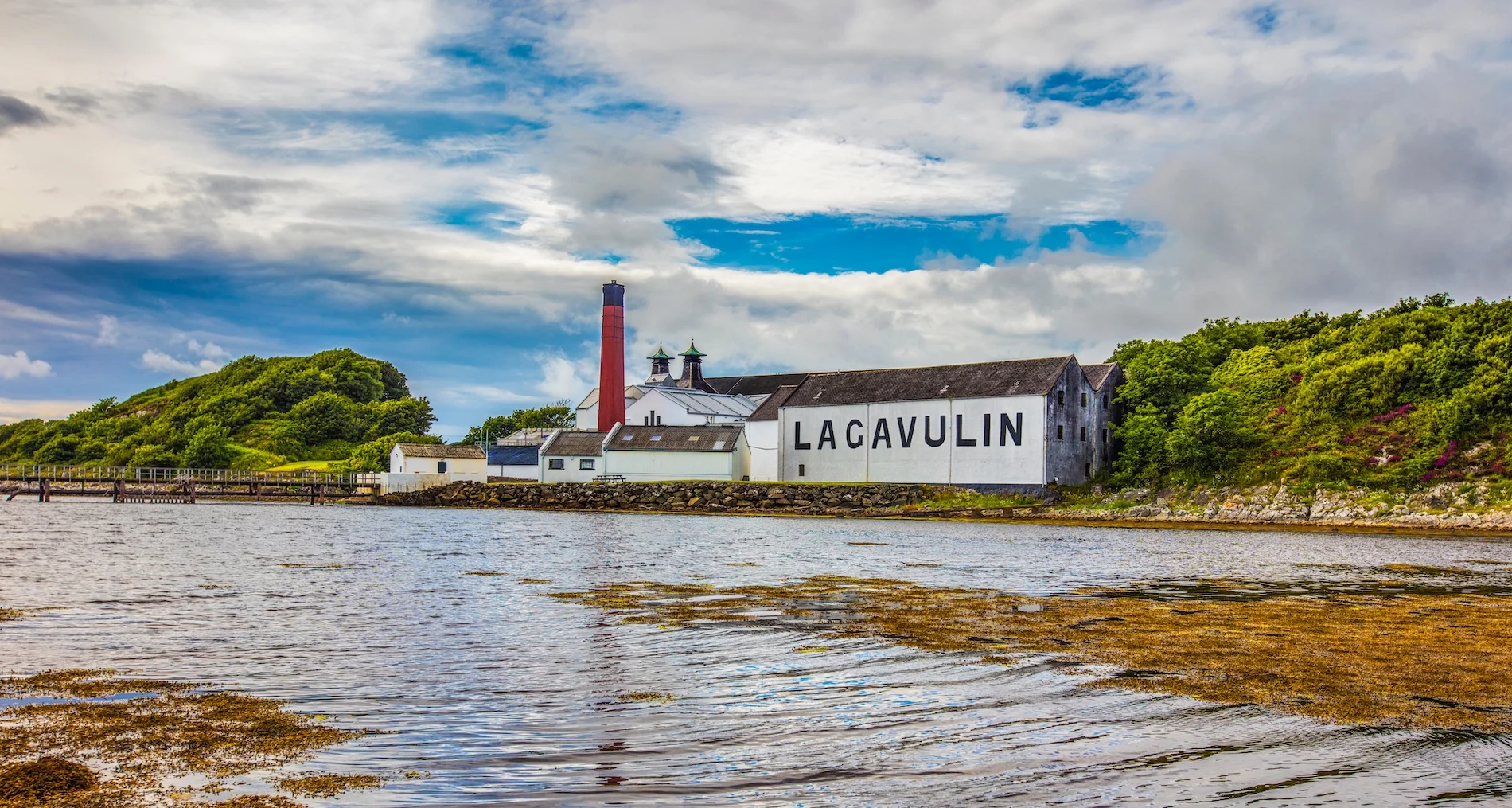 Lagavulin whisky distillery on Scottish coastline with red chimney