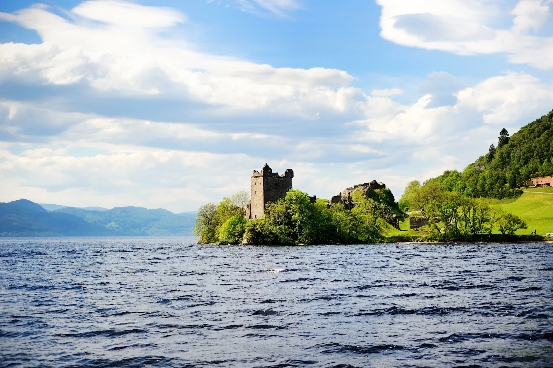 Historic castle ruins on island in Scottish loch with mountains