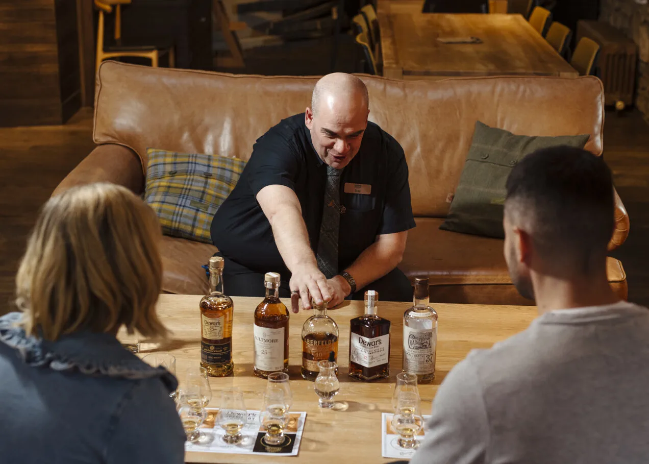Whisky distillery guide conducting a tasting session with visitors