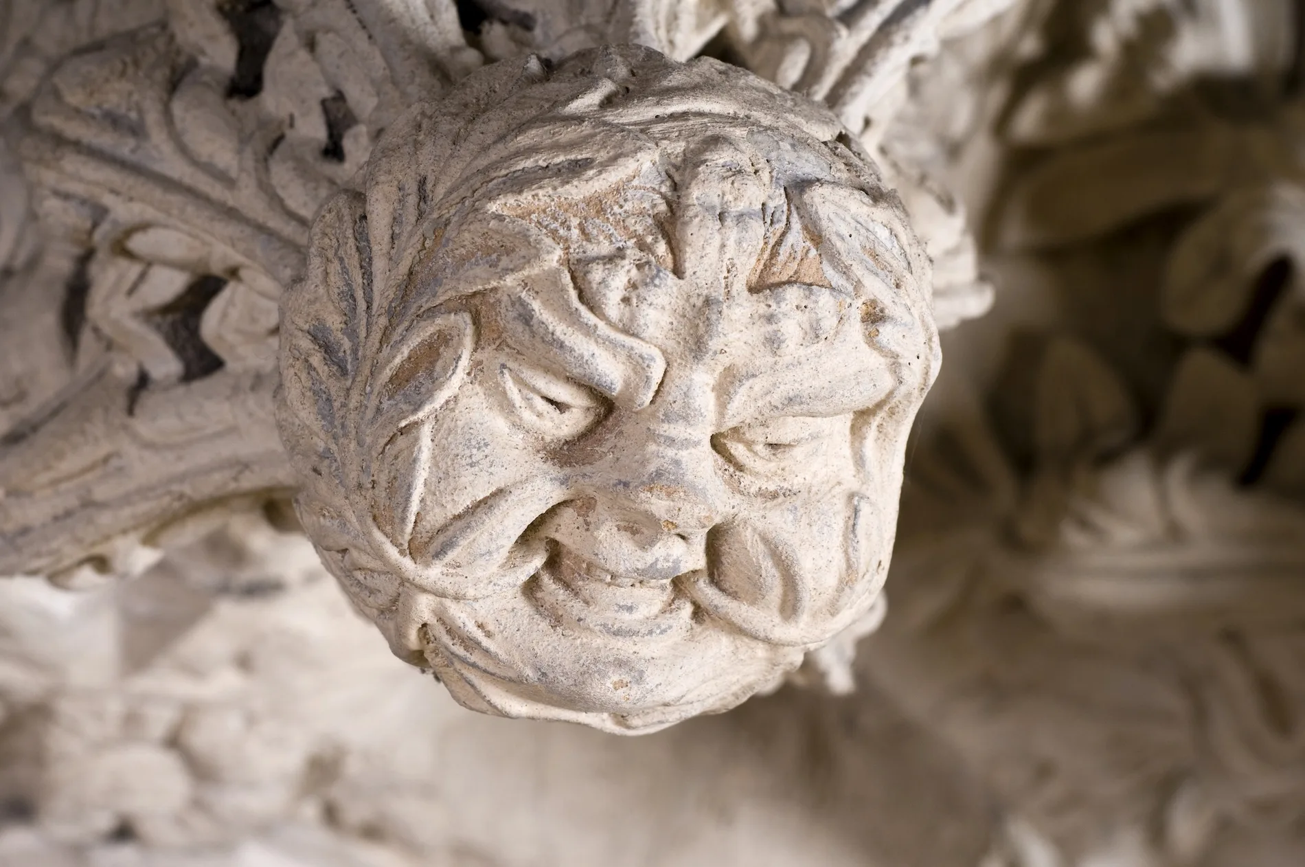 Ornamental stone carving of a cherub head with decorative foliage details