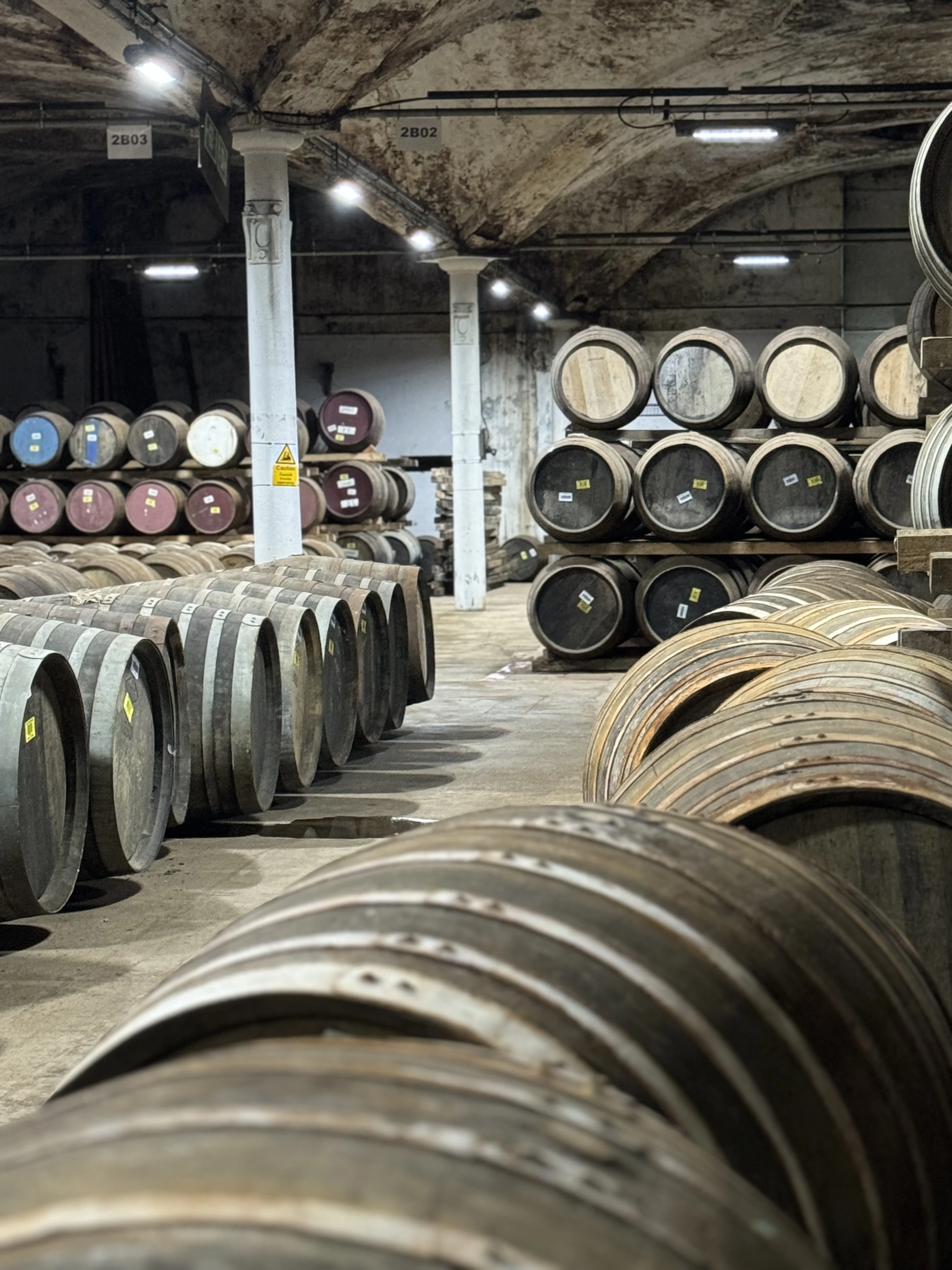 Whisky barrels and wooden staves in Scottish distillery warehouse cellar.