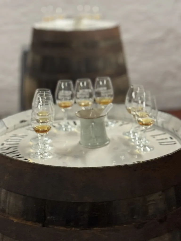 Whisky tasting glasses arranged on barrel table with wooden cask background