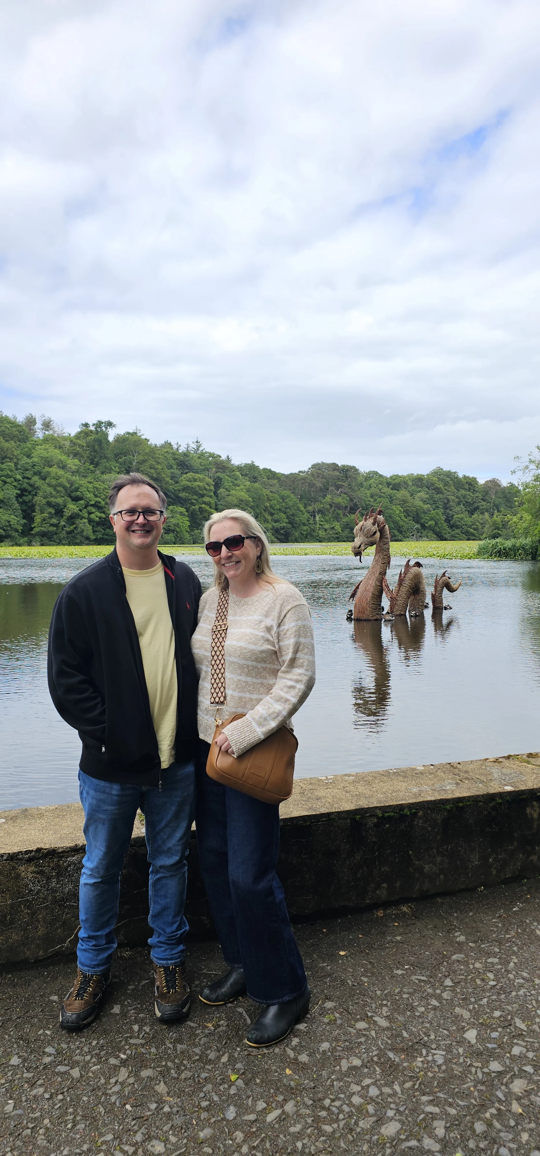 Couple posing by Loch Ness with monster statue in background