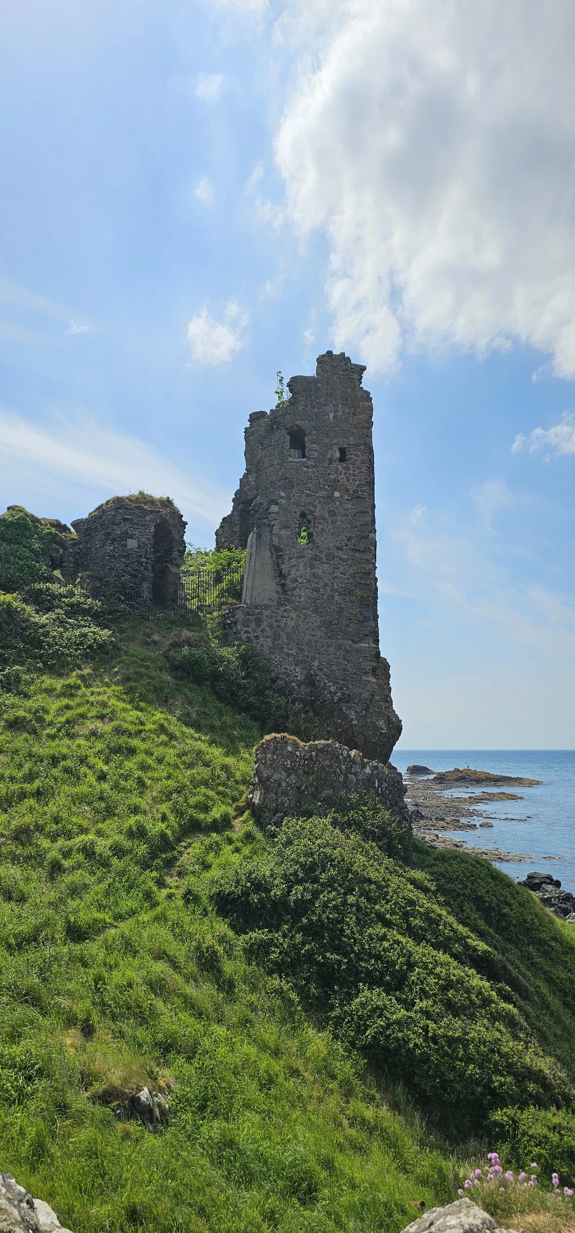 Ruined stone tower on Scottish coastal cliff overlooking the sea