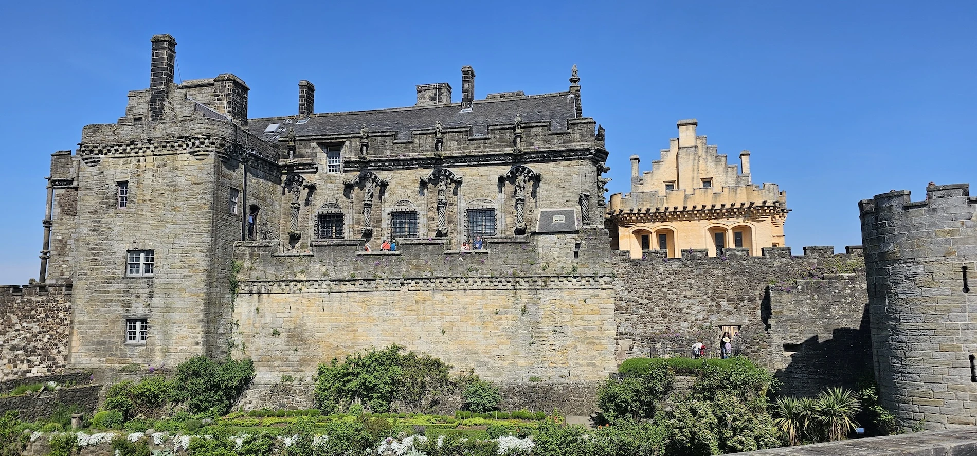 Historic Scottish castle with stone towers and ornate architecture under blue sky