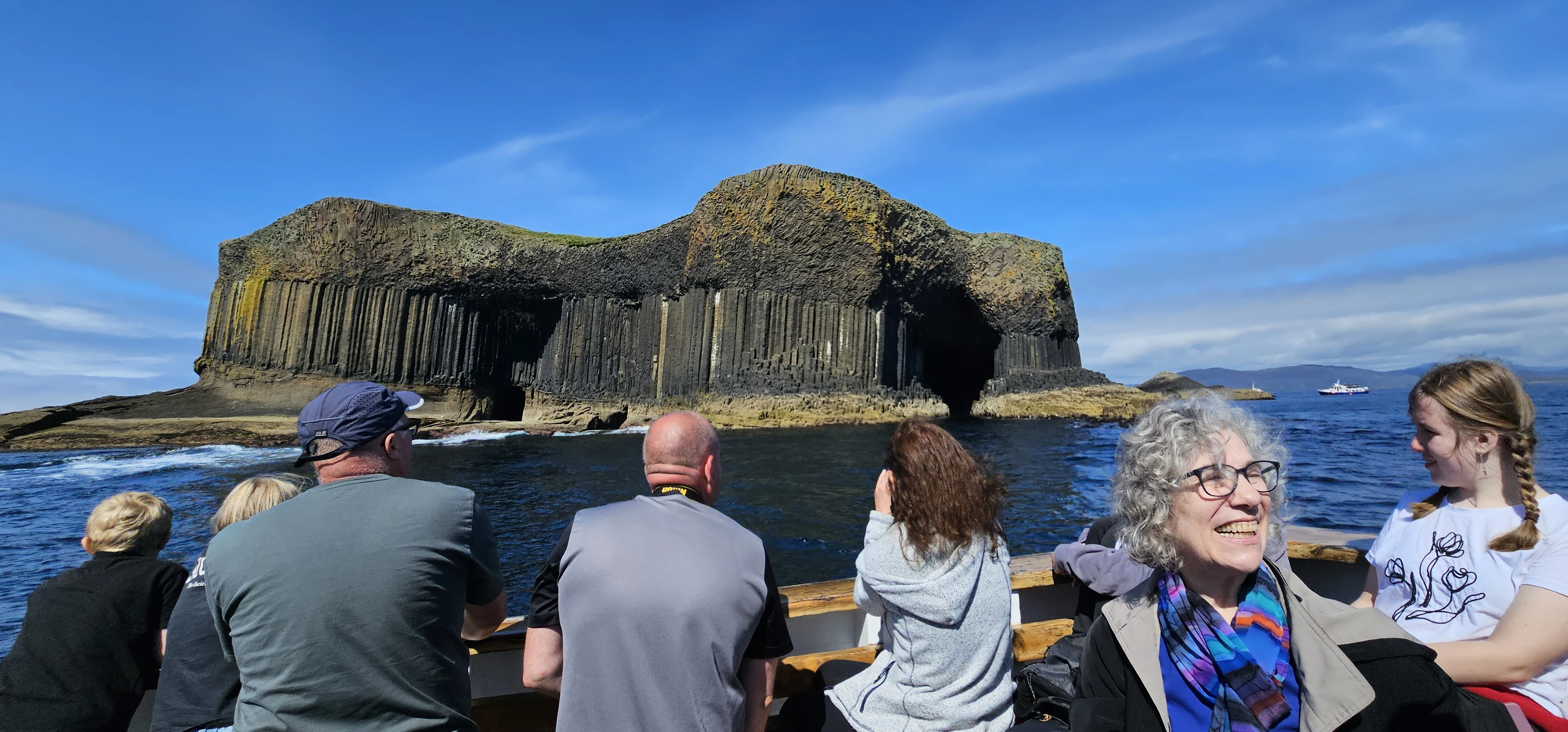 Tourists viewing Fingal's Cave from a boat tour in Scotland