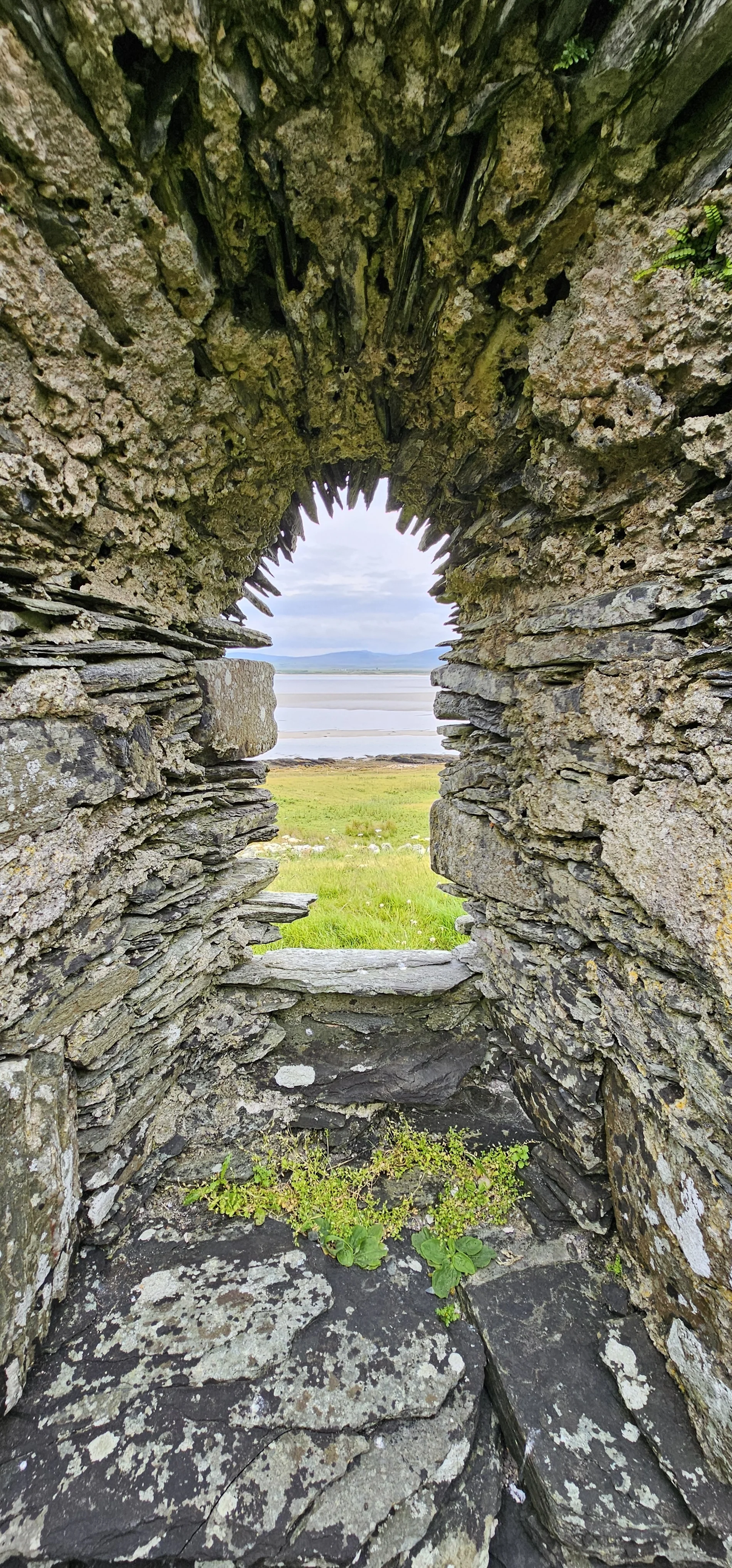 Stone archway framing Scottish loch and mountain landscape view