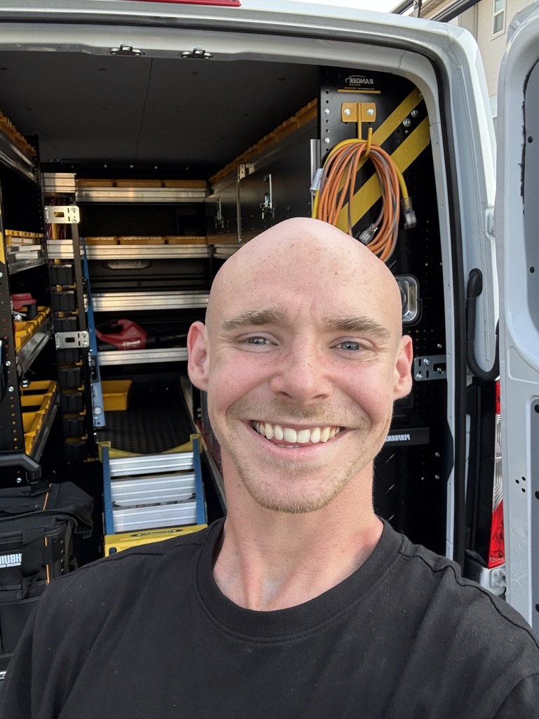 Markas Childs, owner of 630 OVERHEAD, beside his organized service van