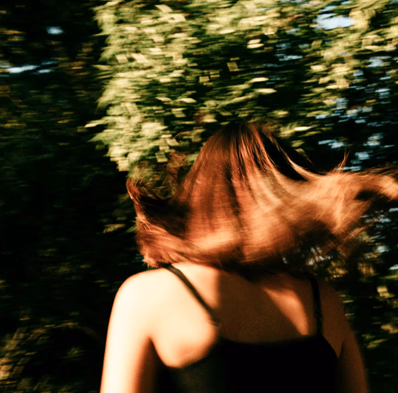 back of girl in trees