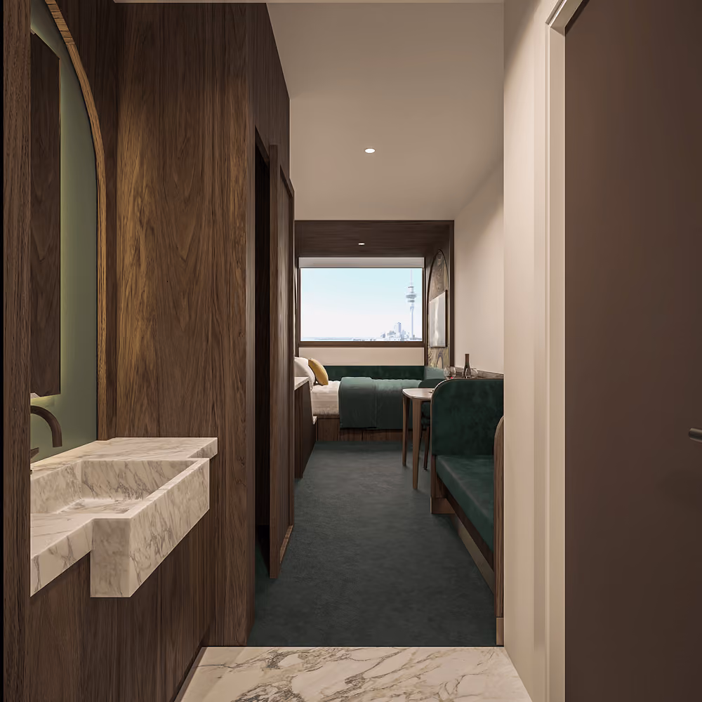Modern hotel room hallway with marble sink, dark wood walls, green carpet, and seating by a window with city view.