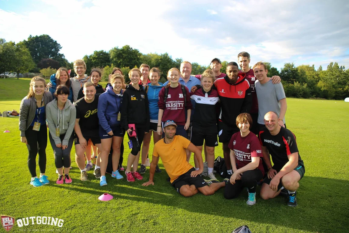 University sports team group photo on a grass pitch after training, with BUCS Outgoing branding below.