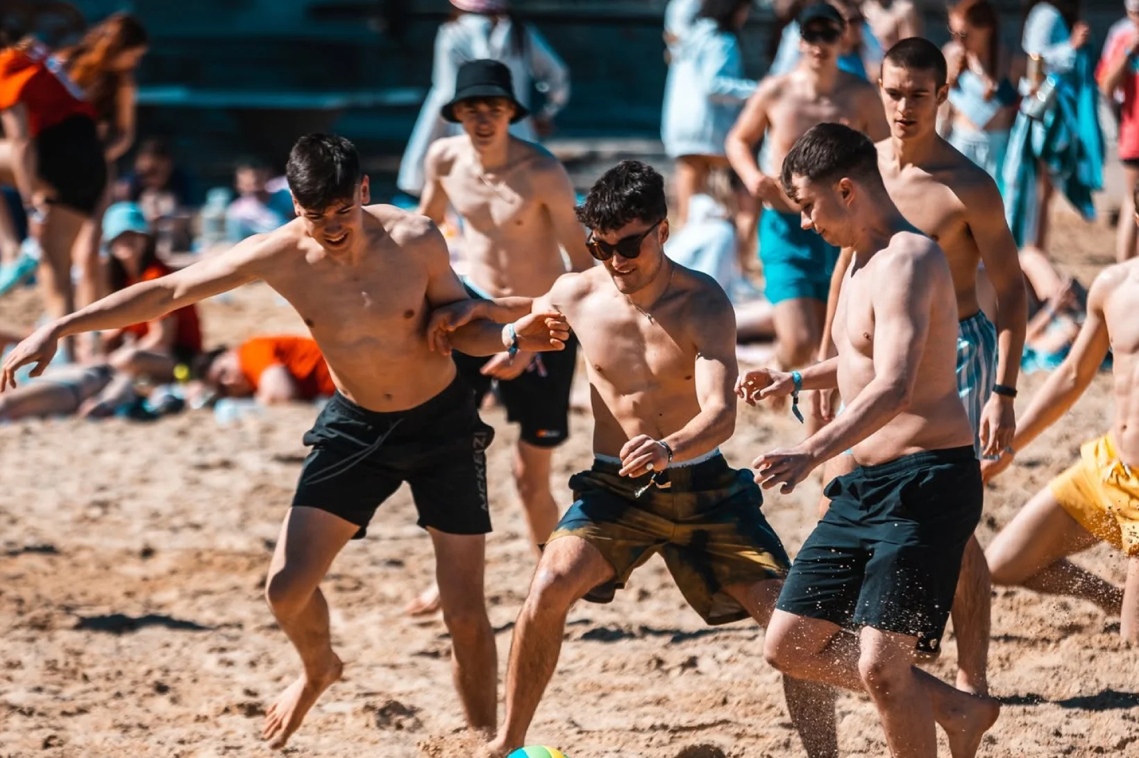 Friends playing beach volleyball together at a party.
