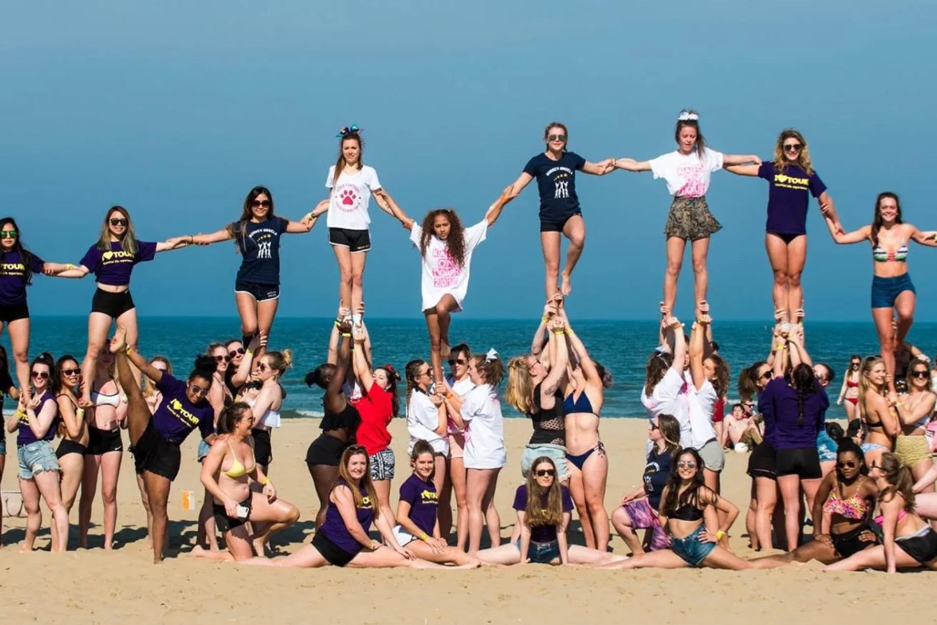 Group taking part in a beach team-building activity on a trip.